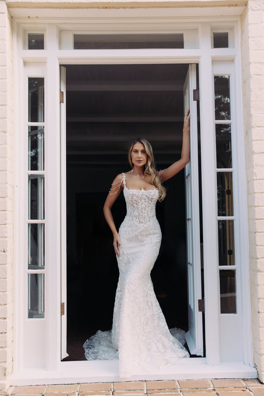 JOLIE Bridal Gown - Wedding dress by Victoria Collection Jessica Couture. Featuring an Fit-N-Flare floral lace gown with chapel train, and delicate pearl chains. 