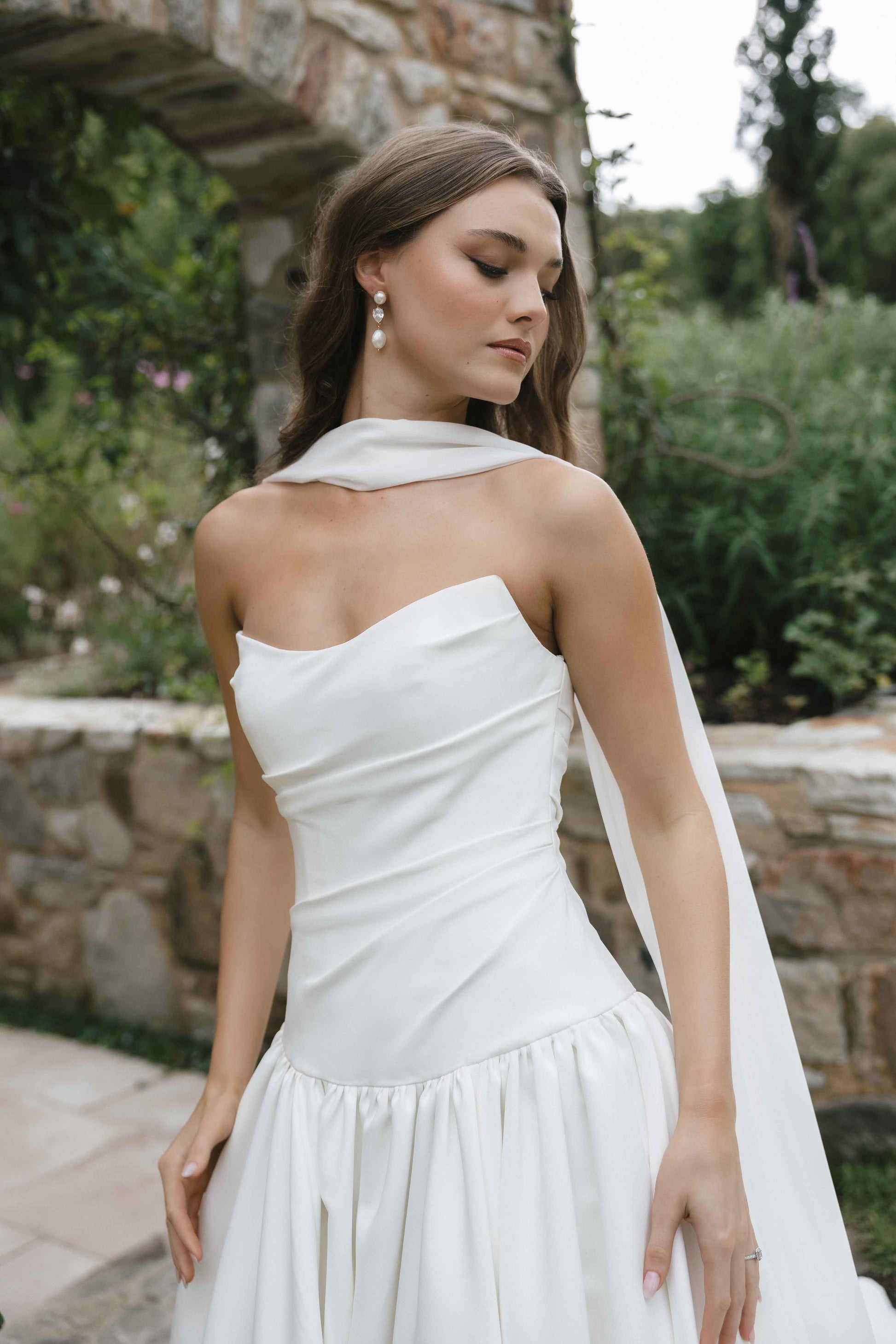 Jana Gown – A-line drop-down waist silhouette with a cat-eye bodice and draped ruching, paired with the Tonica scarf. By Roselle Collection, Jessica Couture.