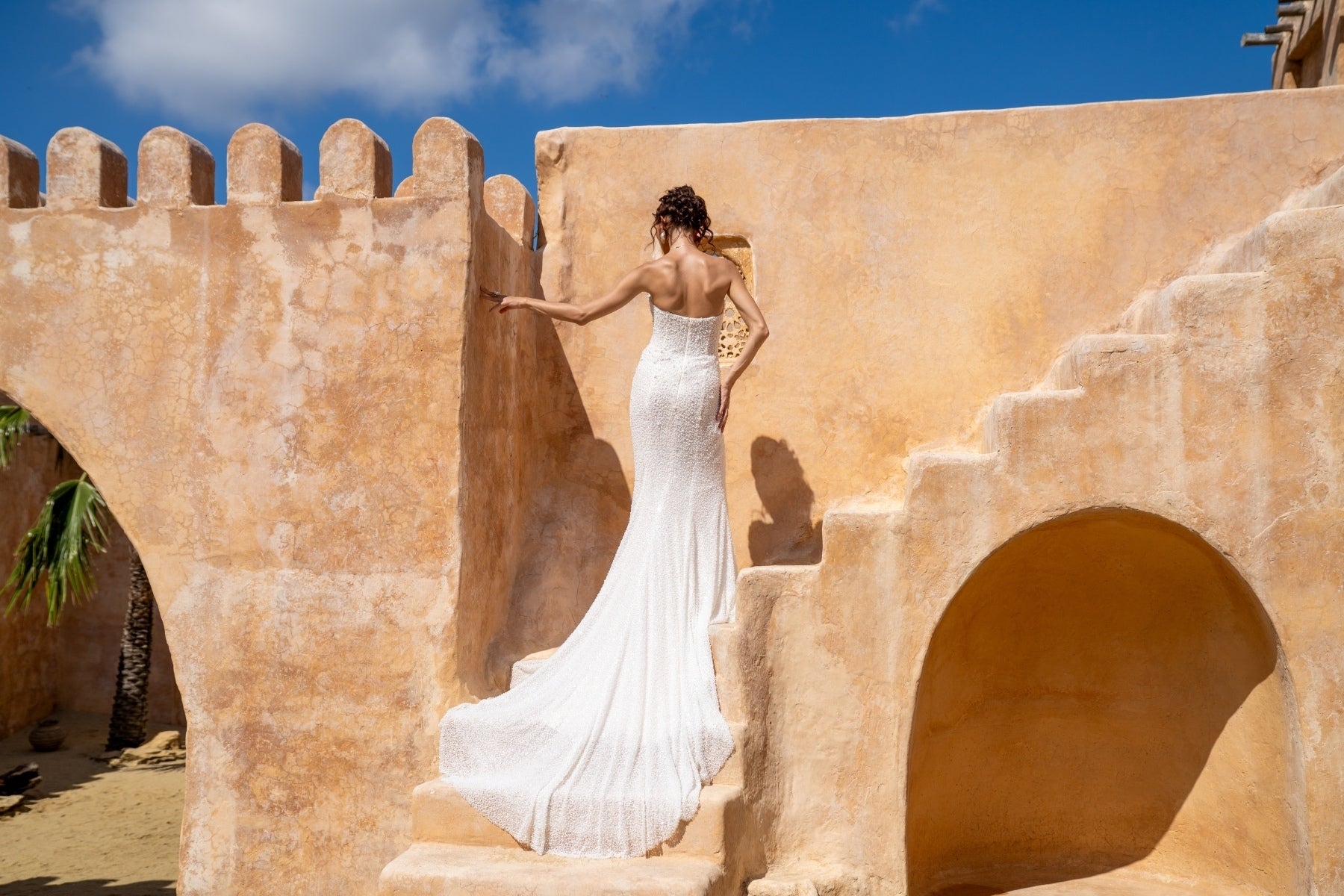 fitted wedding gown with beaded lace, covered in pearls, featuring cat-eye neckline and basque waist. 