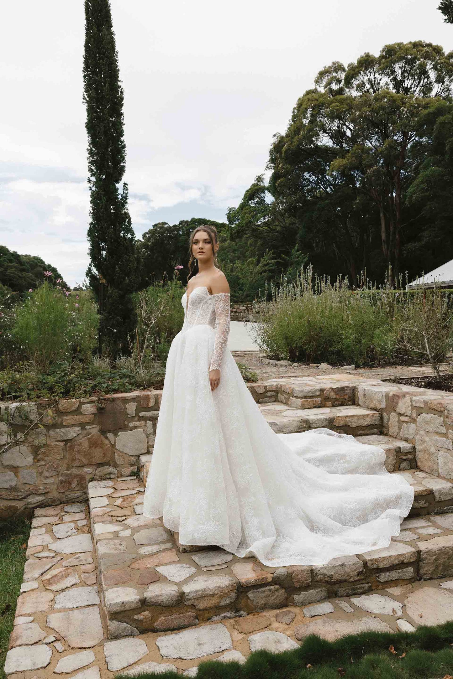 Caitlyn Gown – A-line lace bridal dress with a chapel train, matching lace gloves, and a V-plunge by Roselle collection Jessica Couture