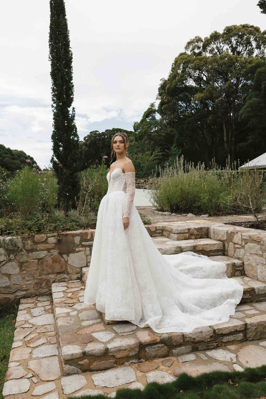 Caitlyn Gown – A-line lace bridal dress with a chapel train, matching lace gloves, and a V-plunge by Roselle collection Jessica Couture
