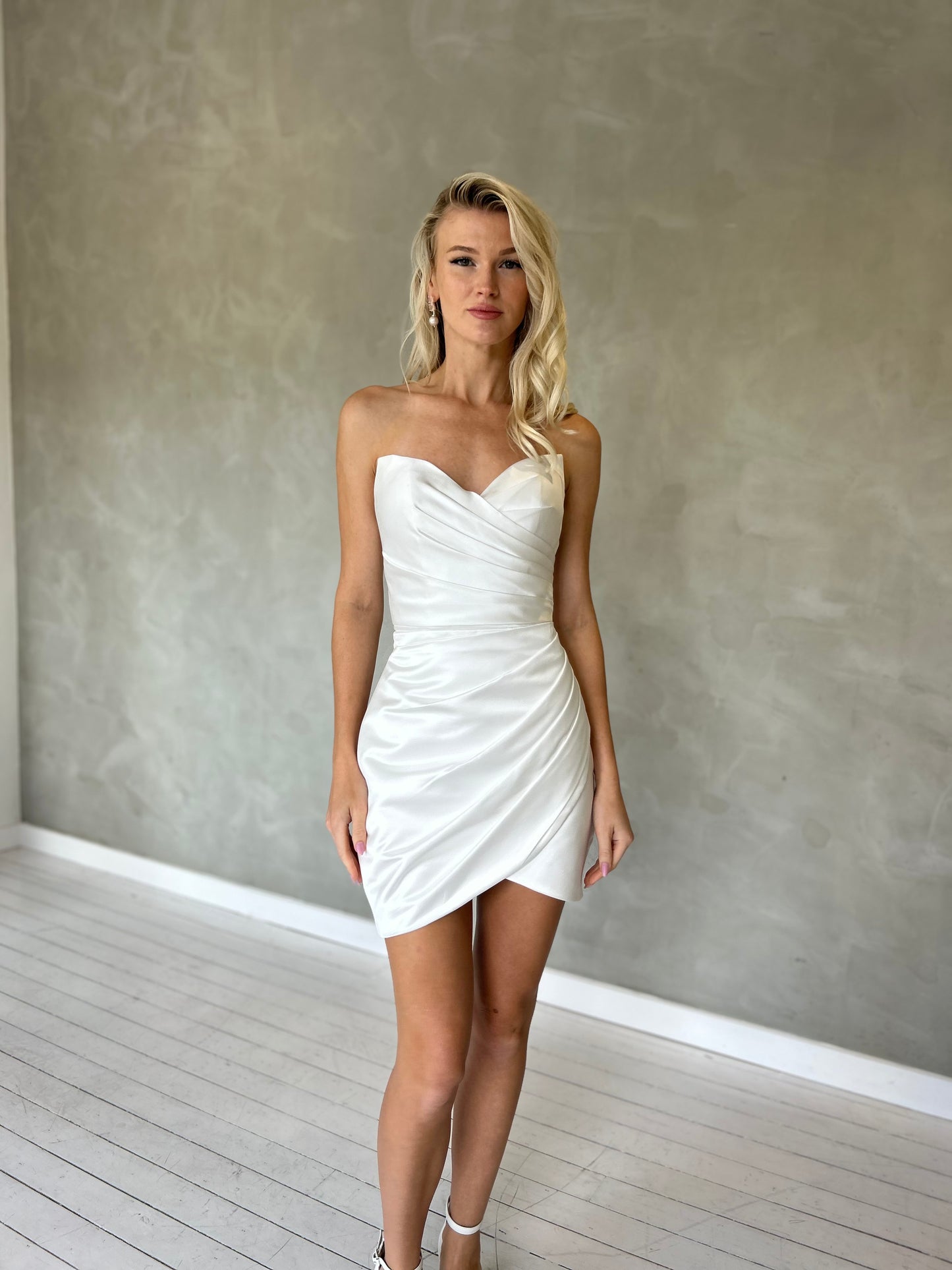 Fitted mini wedding dress in satin fabric, featuring a strapless sweetheart neckline with Ruching 