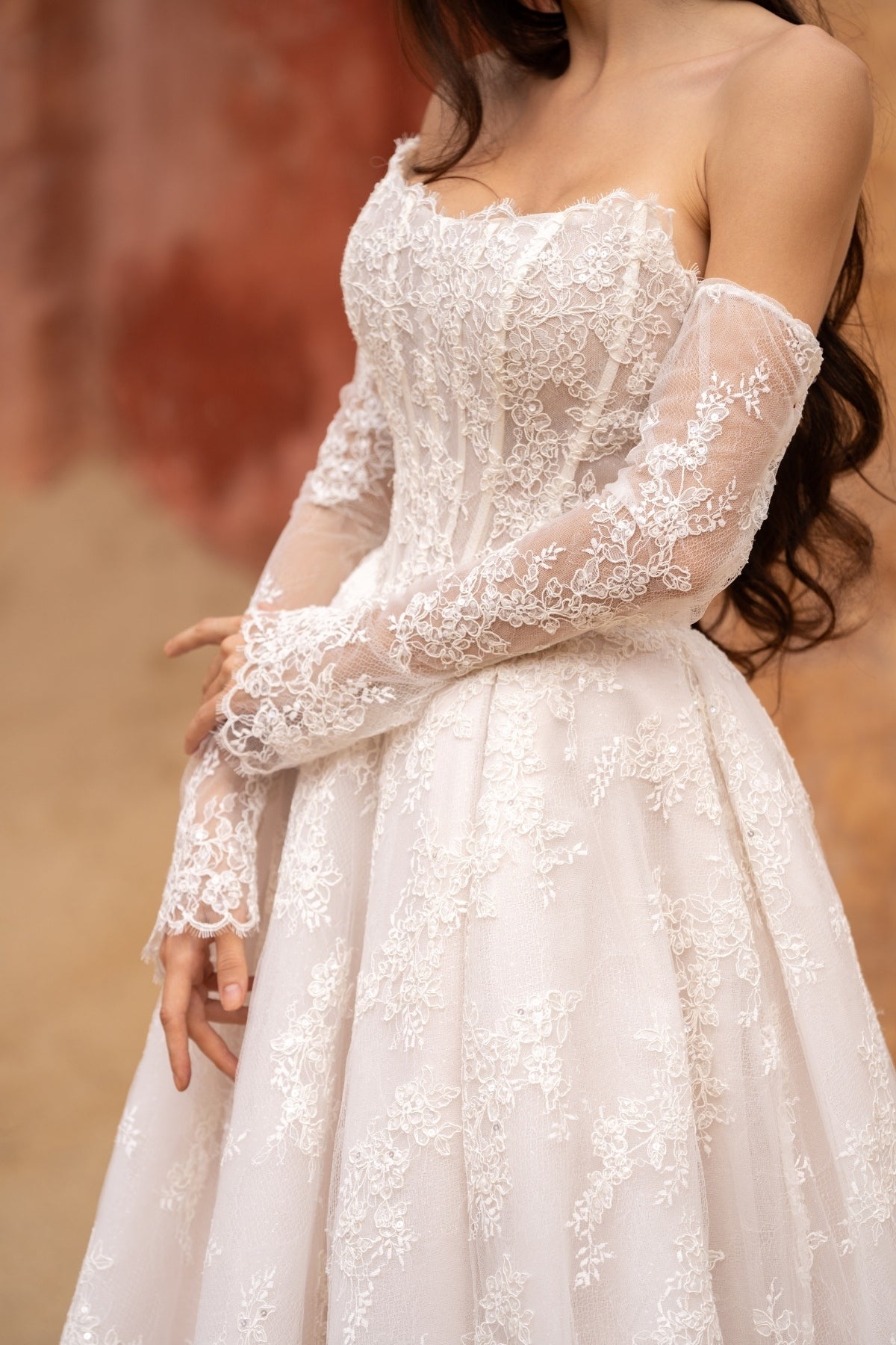 Lace A-line wedding dress with cat-eye neckline and basque waist. paired with fitted lace sleeves. 