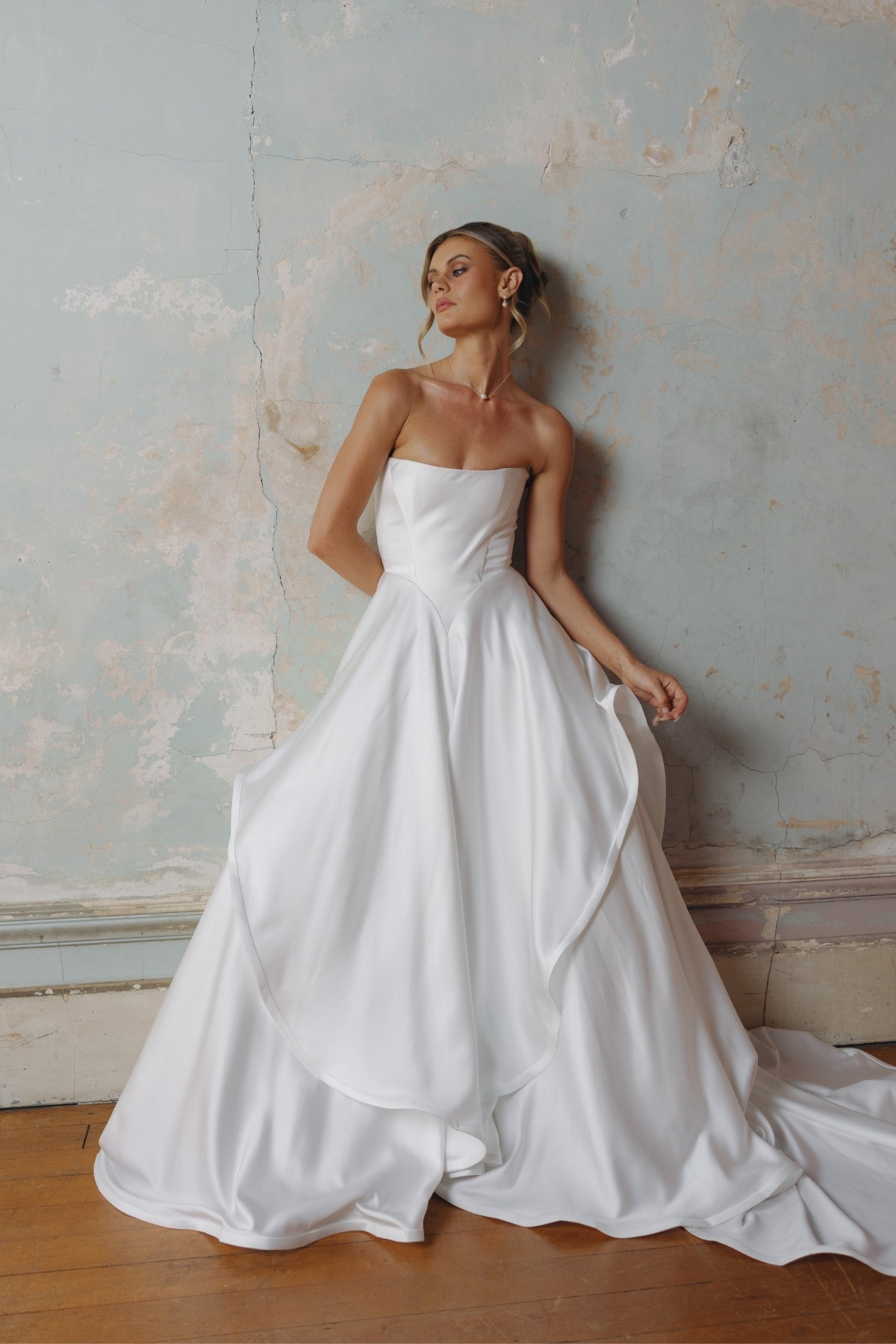 Strapless A-line satin wedding gown featuring cut drapes on the skirt 