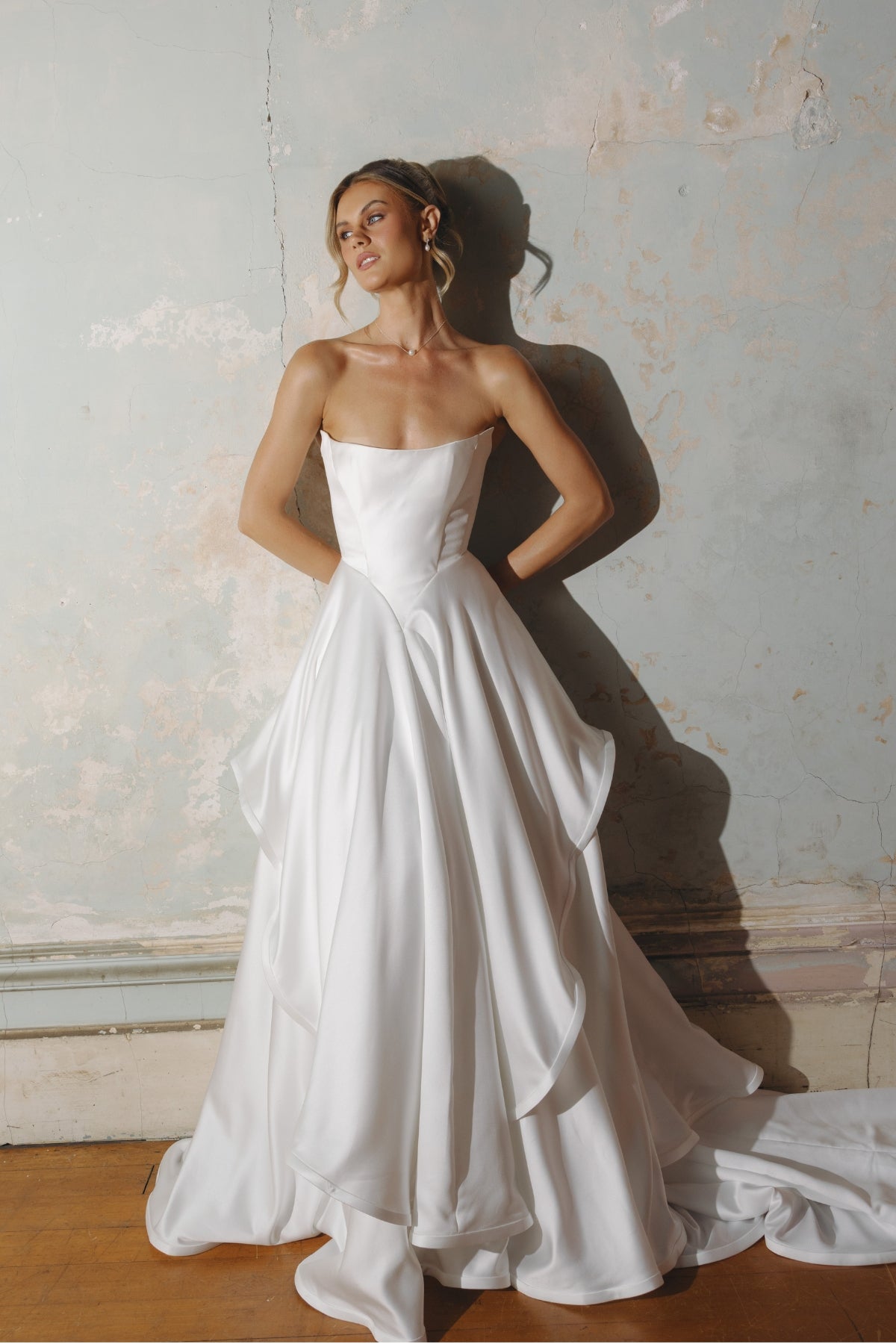 Strapless A-line satin wedding gown featuring cut drapes on the skirt 