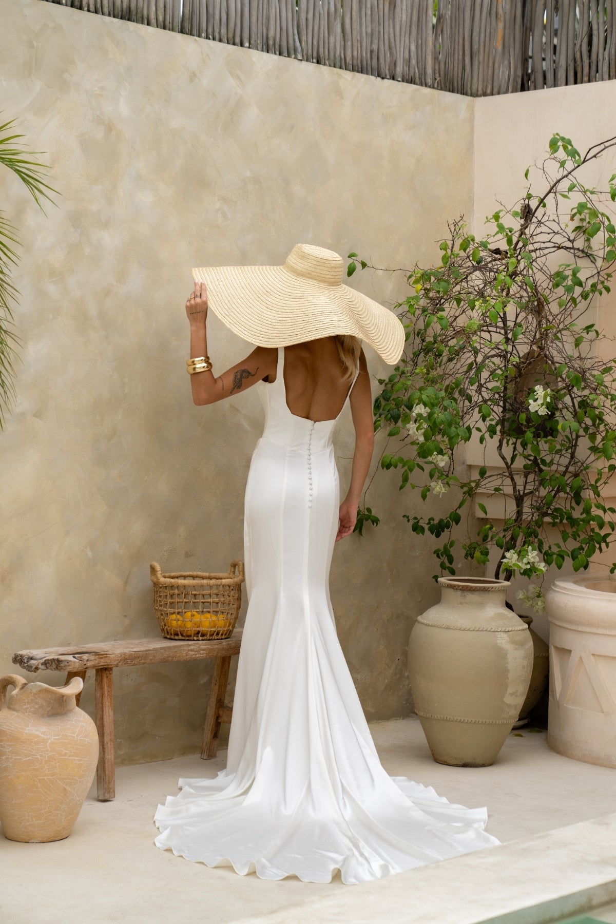 fitted plain wedding dress featuring square neckline with straps, boning on bodice and slight drape around the hips. minimal vibes 