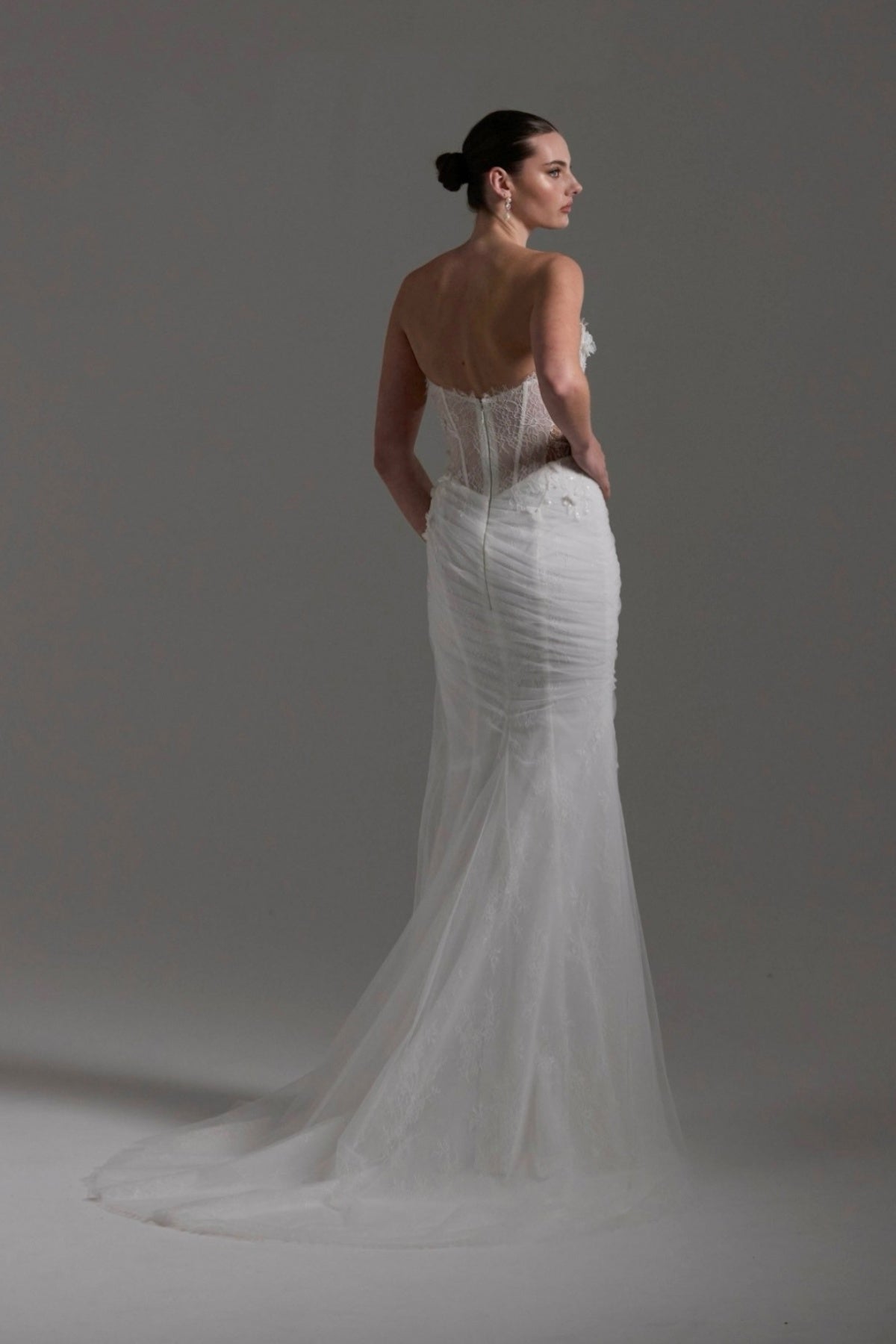 Fitted Bridal gown with floral lace scattered around the corseted bodice, basque waistline. 