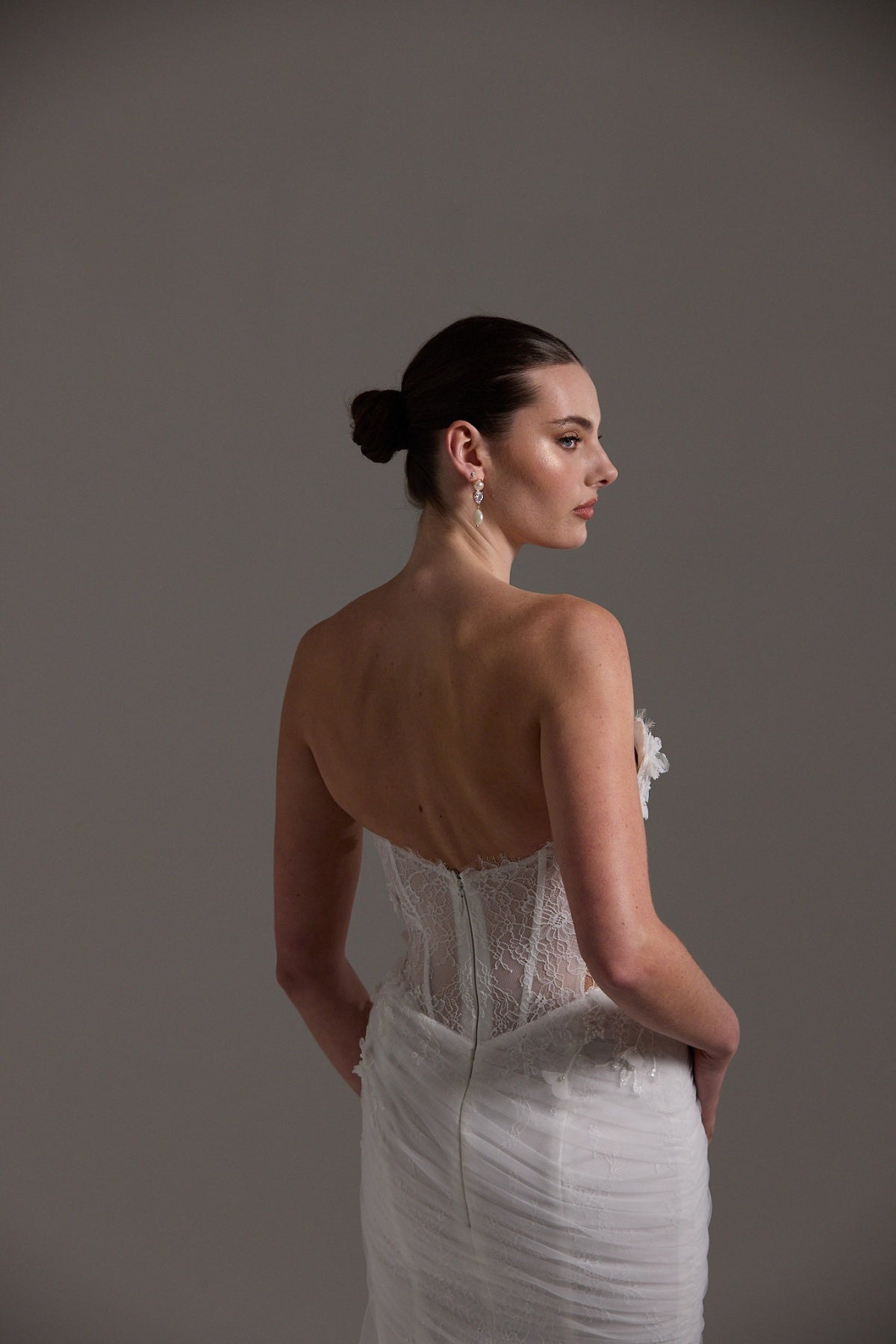 Fitted Bridal gown with floral lace scattered around the corseted bodice, basque waistline. 