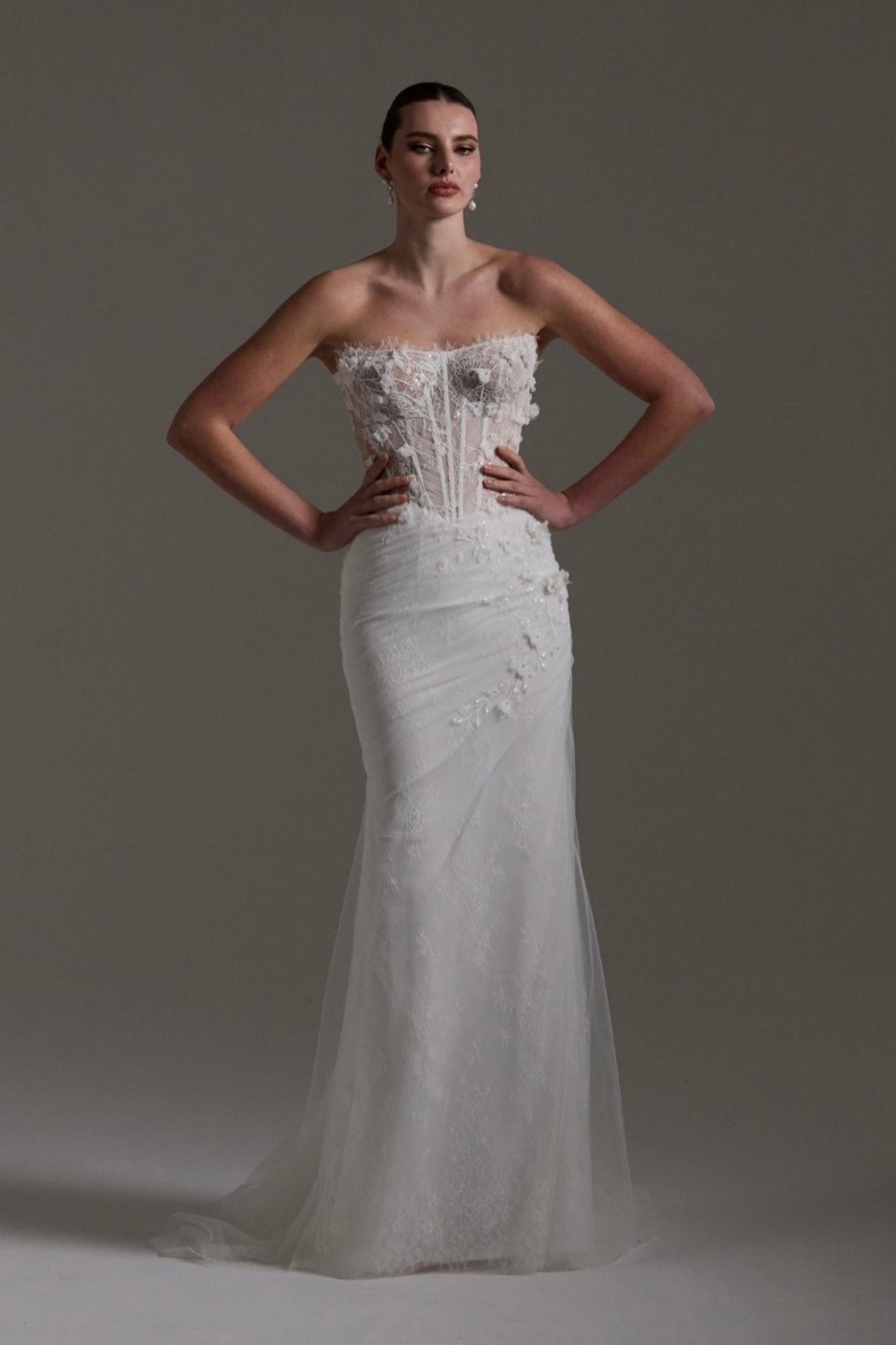 Fitted Bridal gown with floral lace scattered around the corseted bodice, basque waistline. 