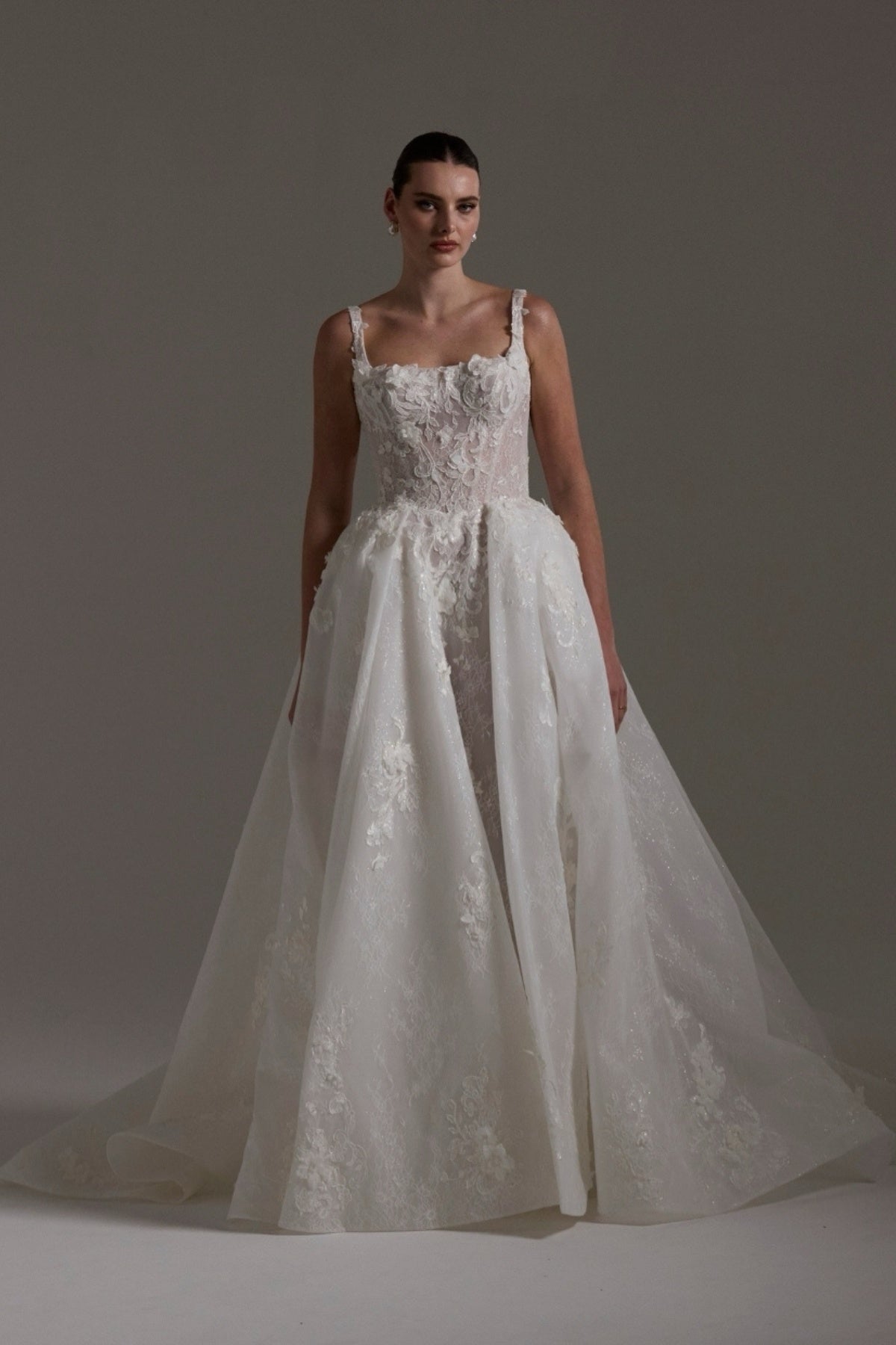A-line Wedding gown featuring a square neckline, ballgown skirt, and lace. 