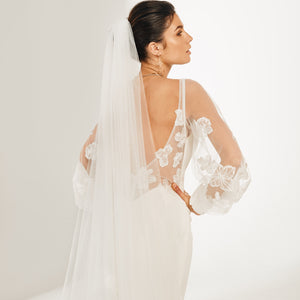 Mid shot of bride in backless dress with tulle Orangina Veil with embroidered flowers