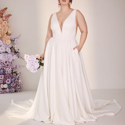 Wedding gown in ivory with illusion mesh v-neck and v sides. A-line skirt with pockets.