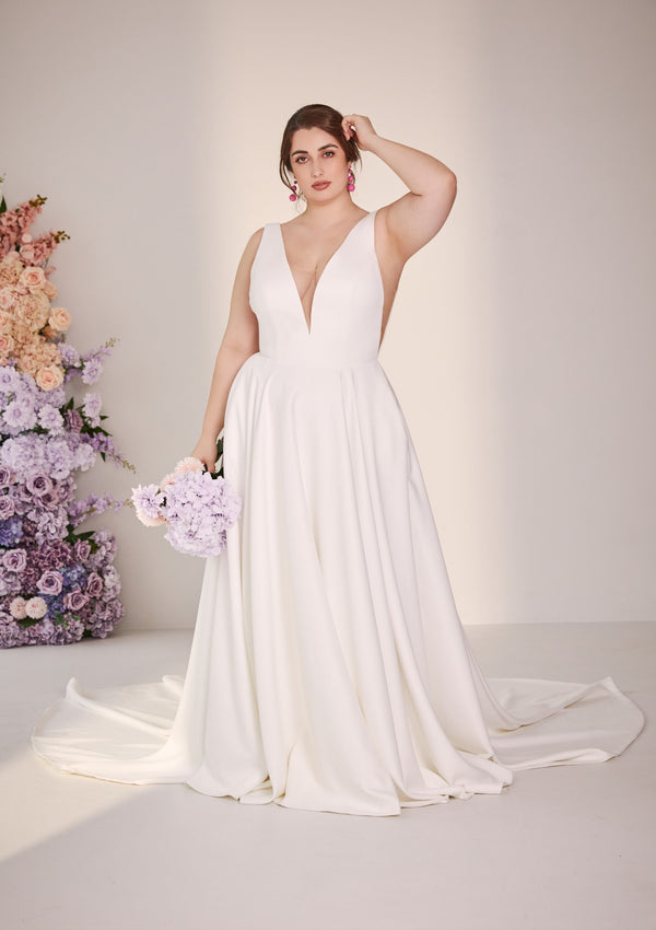 Wedding gown in ivory with illusion mesh v-neck and v sides. A-line skirt with pockets.