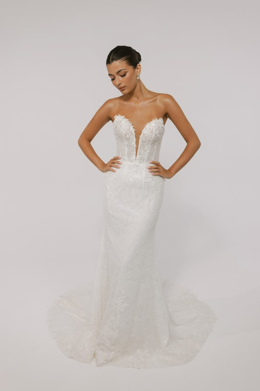 Fitted wedding gown with a deep v plunge, strapless neckline, beaded lace. 