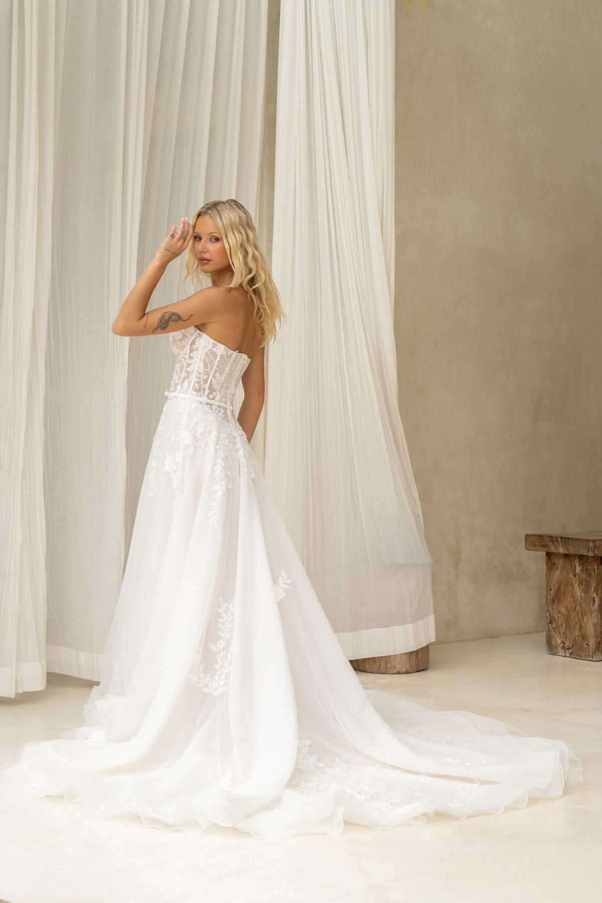 A-line wedding dress with v-plunge sweetheart neckline, floral lace, waistbelt and subtle basque waist, flowing tulle skirt. 