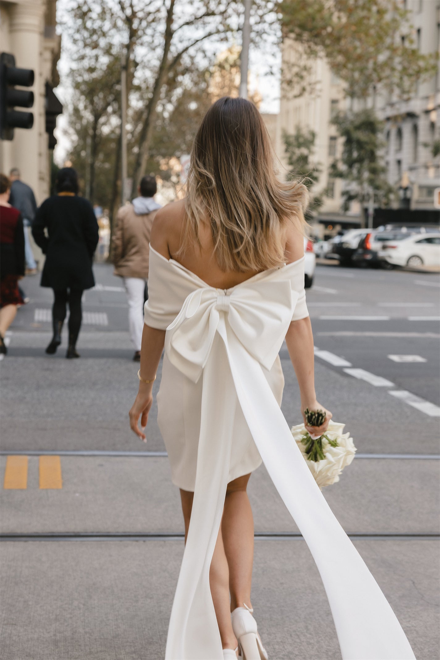 Mini Bridal dress with off-the-shoulder draped sleeves flowing into a full corset bodice, draping into a criss-cross pencil skirt. 