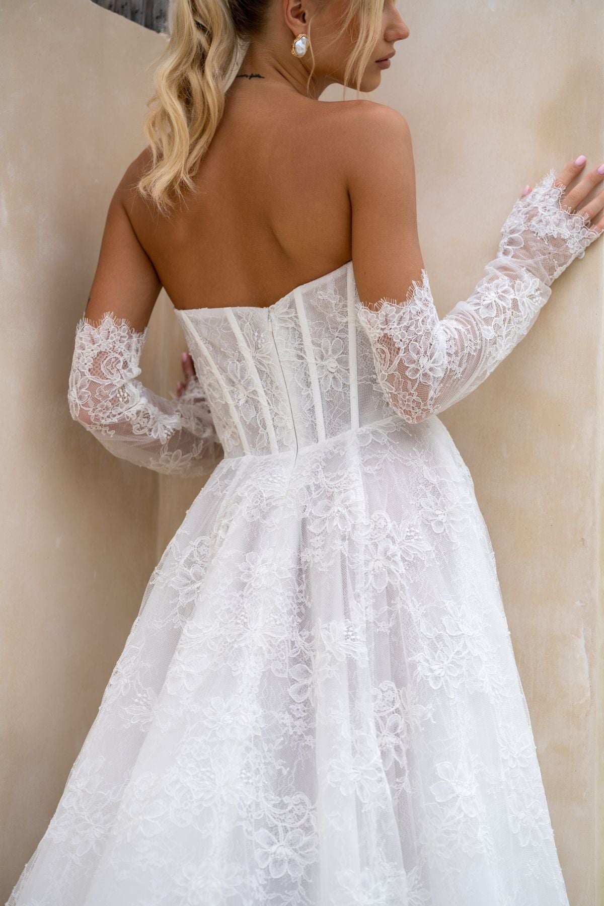 Lace A-line wedding gown with deep v plunge and sweetheart neckline, basque wasitline and fitted lace sleeves. 