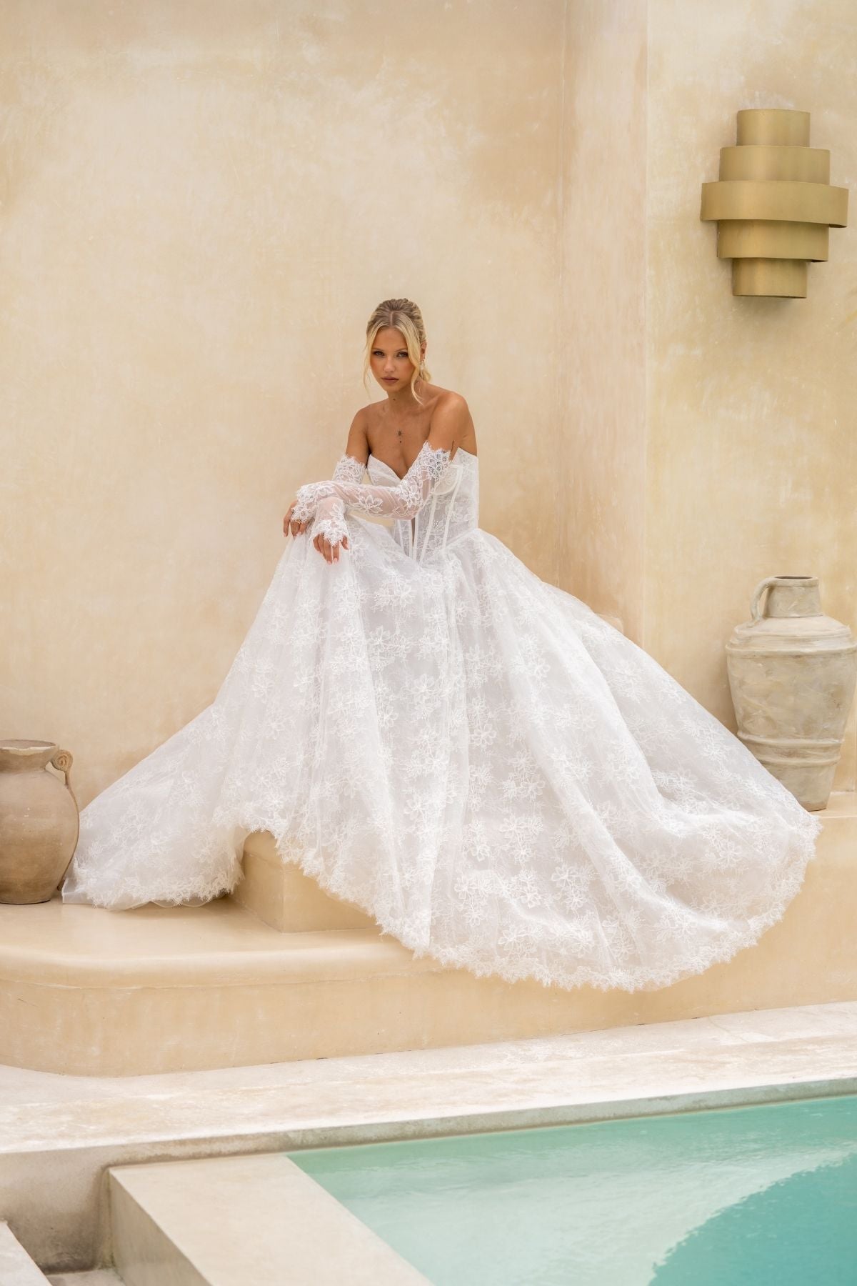 Lace A-line wedding gown with deep v plunge and sweetheart neckline, basque wasitline and fitted lace sleeves. 