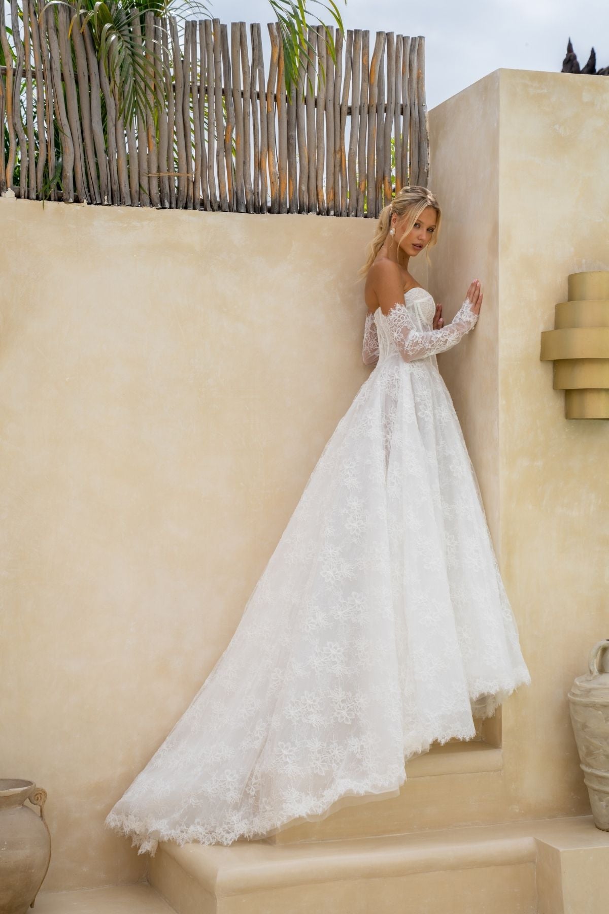 Lace A-line wedding gown with deep v plunge and sweetheart neckline, basque wasitline and fitted lace sleeves. 