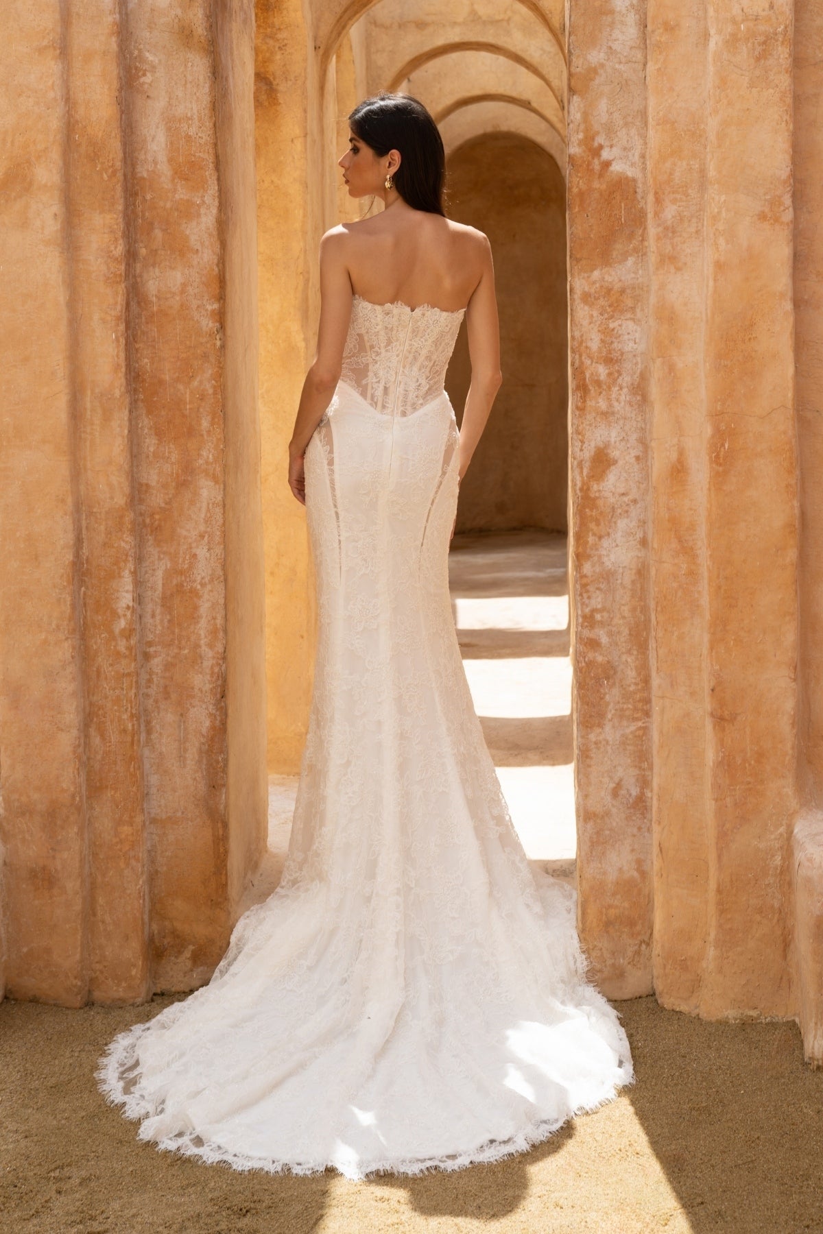 fitted lace wedding dress with basque waist, cat-eye neckline and side cut-outs. paired with fitted lace sleeves. 