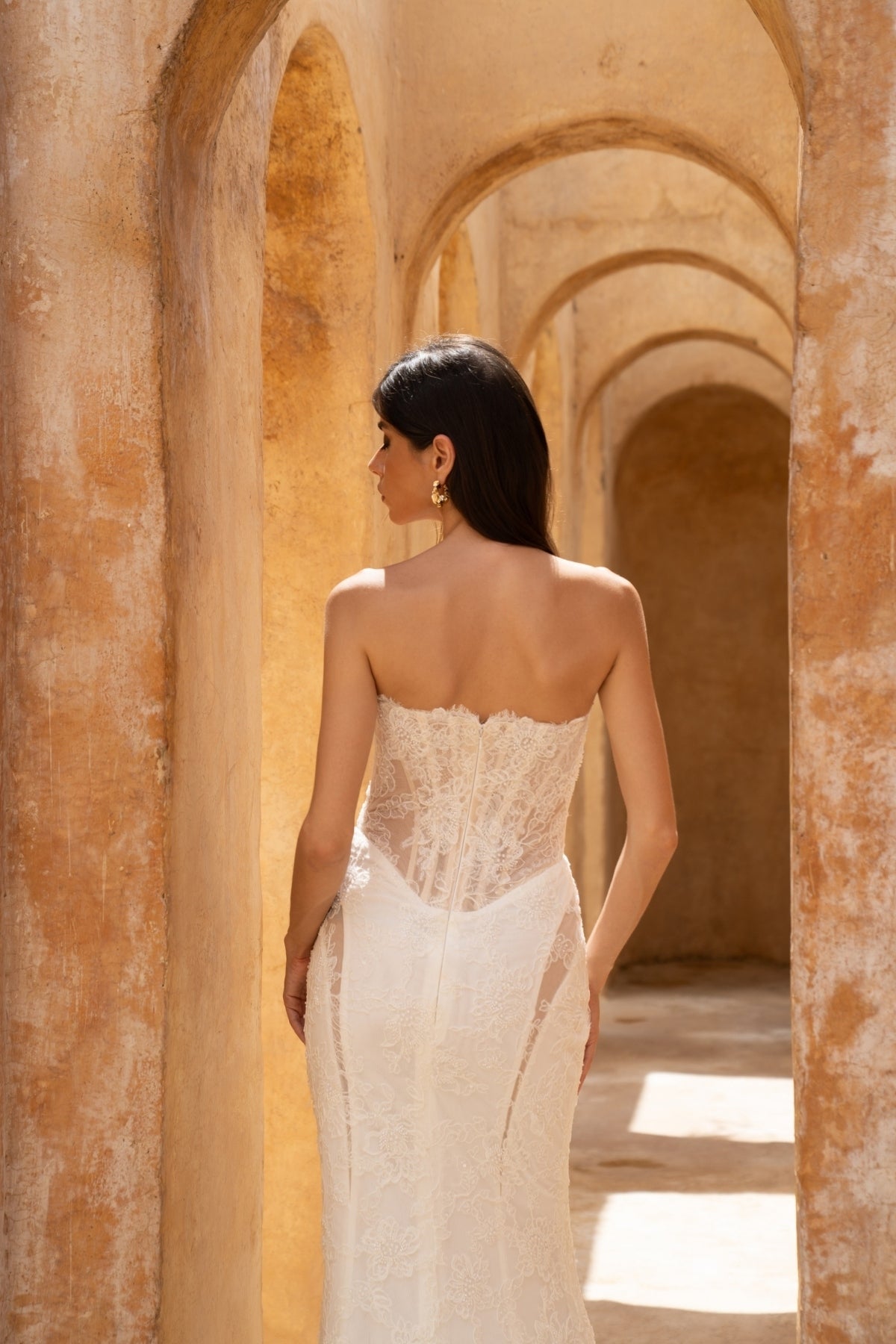 fitted lace wedding dress with basque waist, cat-eye neckline and side cut-outs. paired with fitted lace sleeves. 