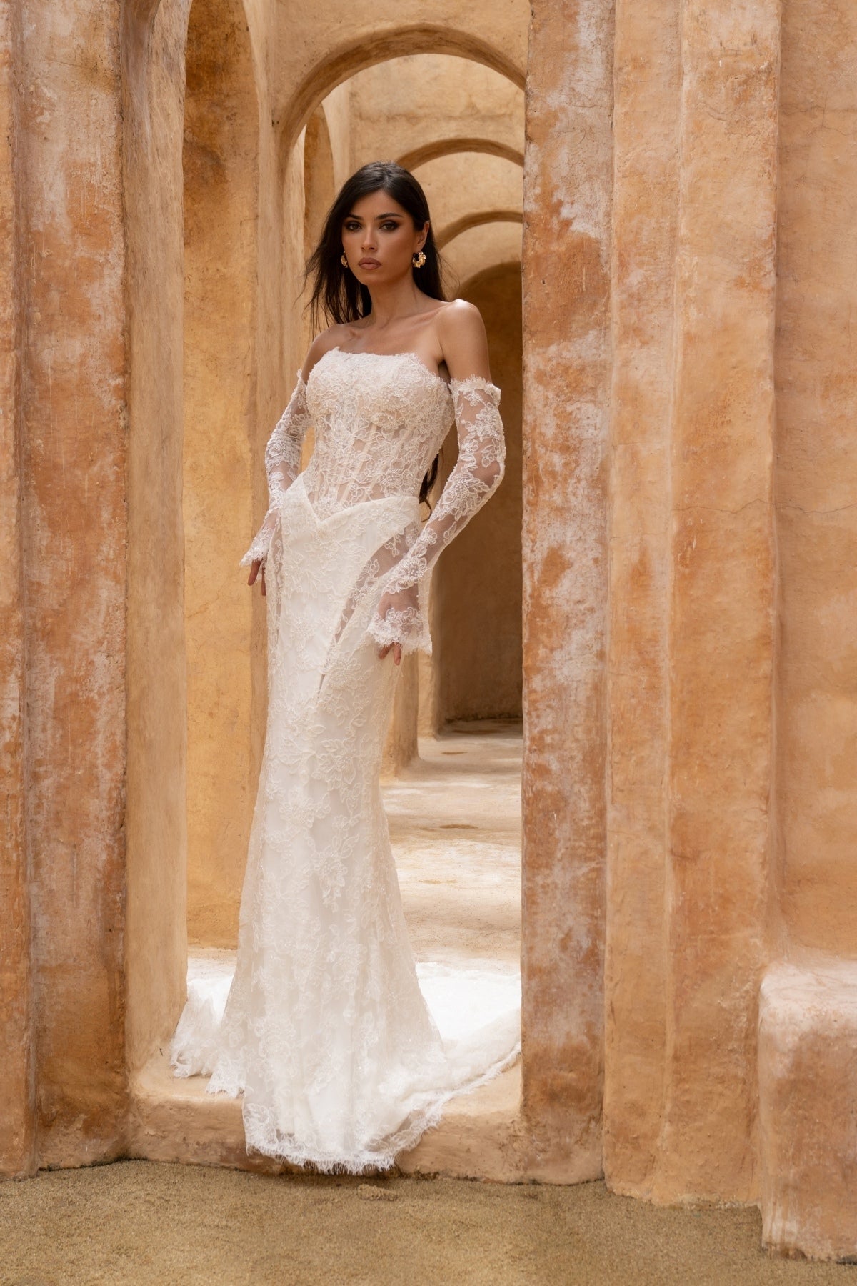 fitted lace wedding dress with basque waist, cat-eye neckline and side cut-outs. paired with fitted lace sleeves. 