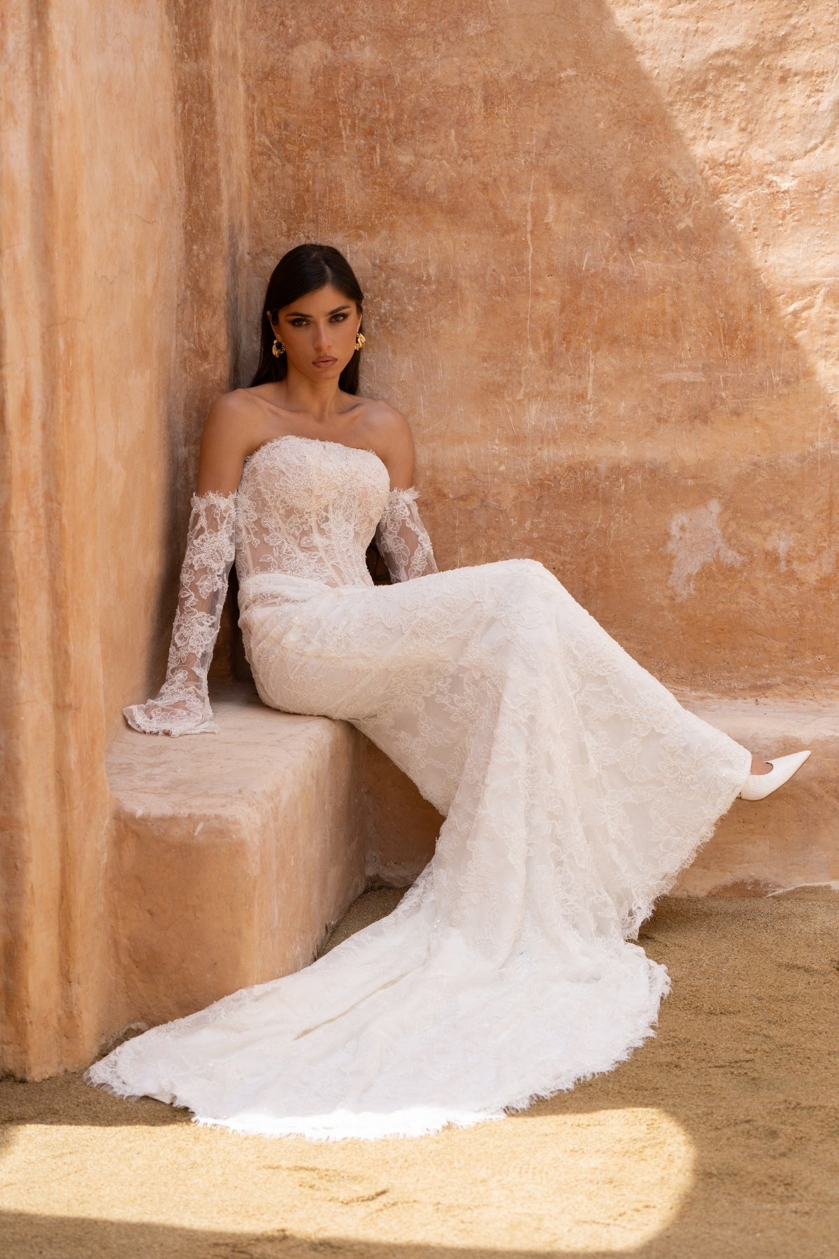 fitted lace wedding dress with basque waist, cat-eye neckline and side cut-outs. paired with fitted lace sleeves. 