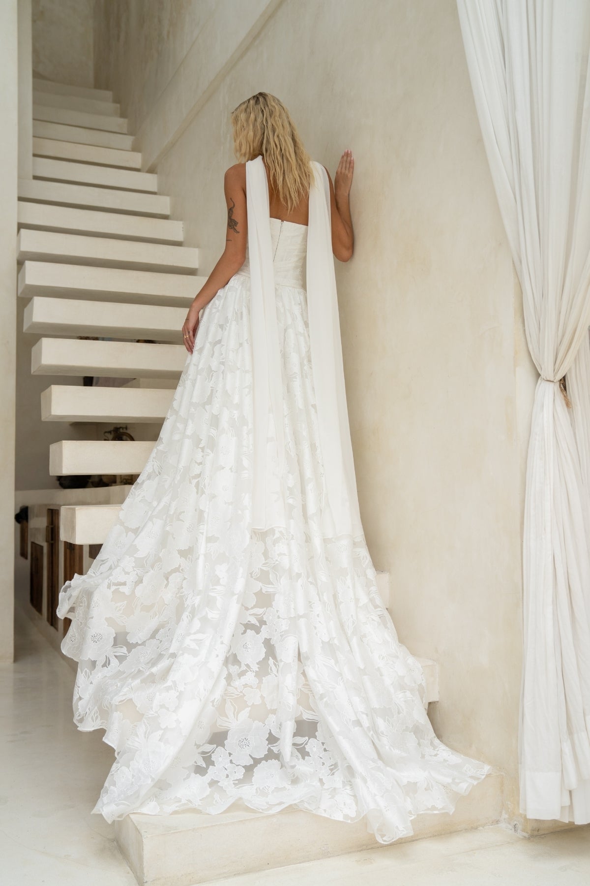 A-line drapy wedding gown featuring a cat-eye neckline, corseted bodice, and floral jacquard fabric. 