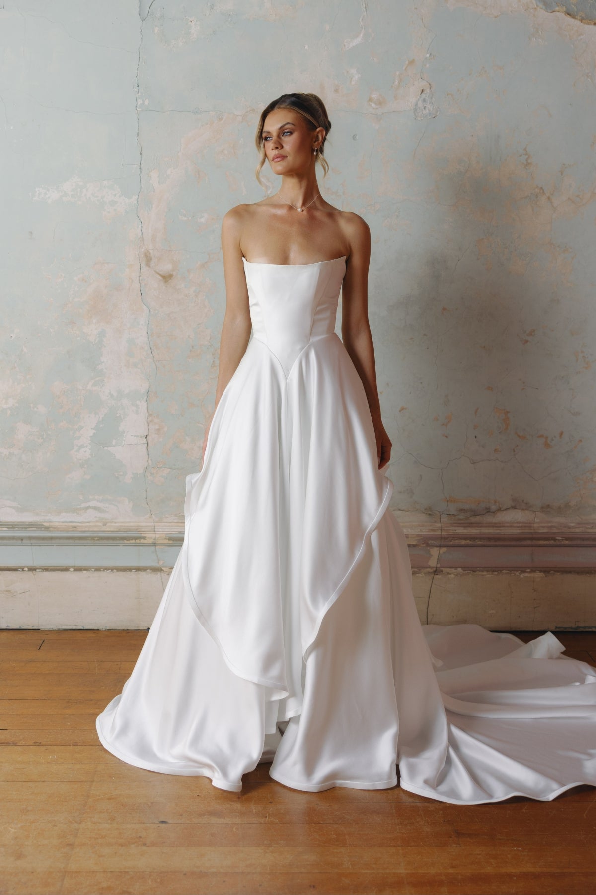 Strapless A-line satin wedding gown featuring cut drapes on the skirt 