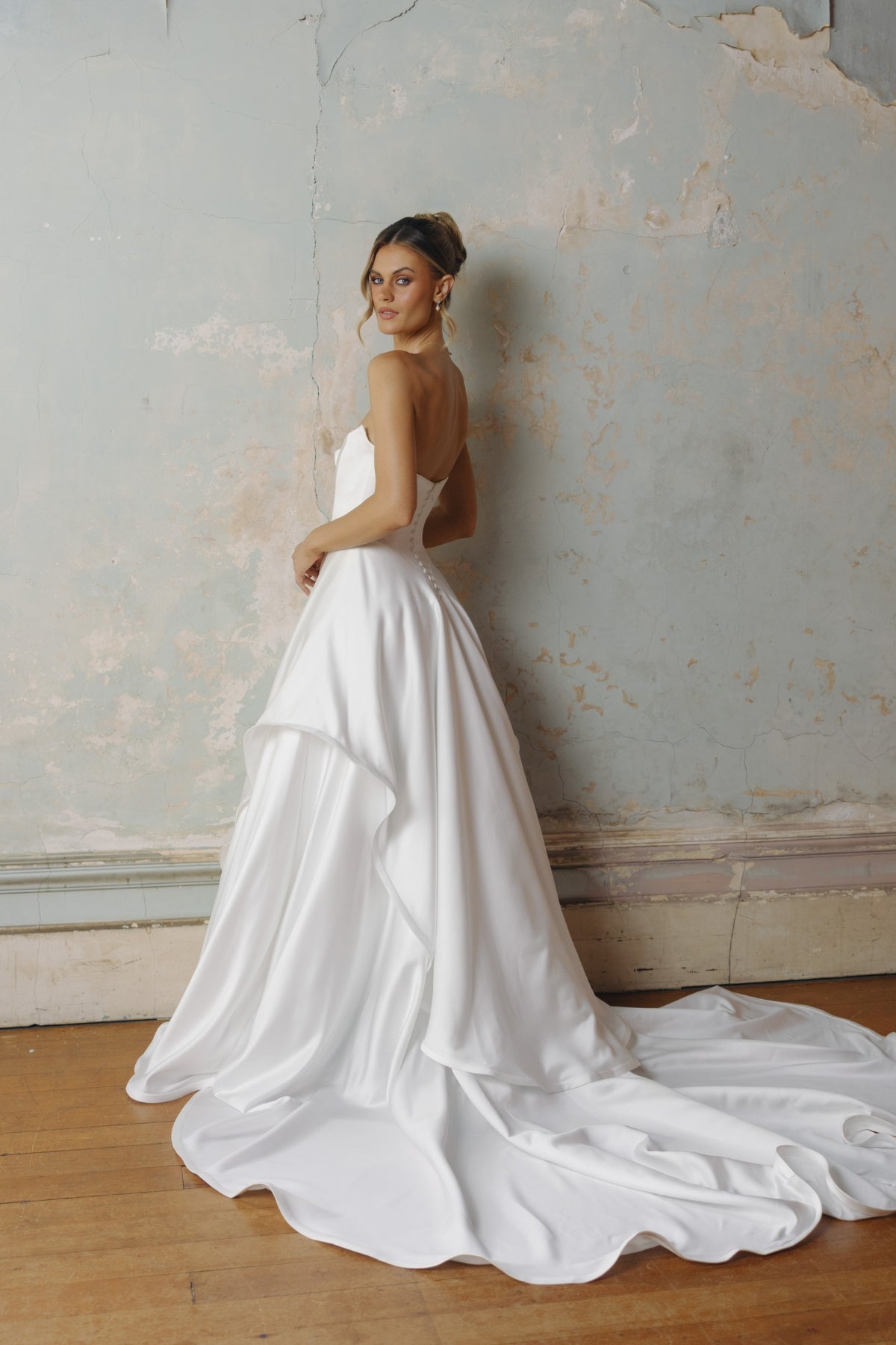 Strapless A-line satin wedding gown featuring cut drapes on the skirt 