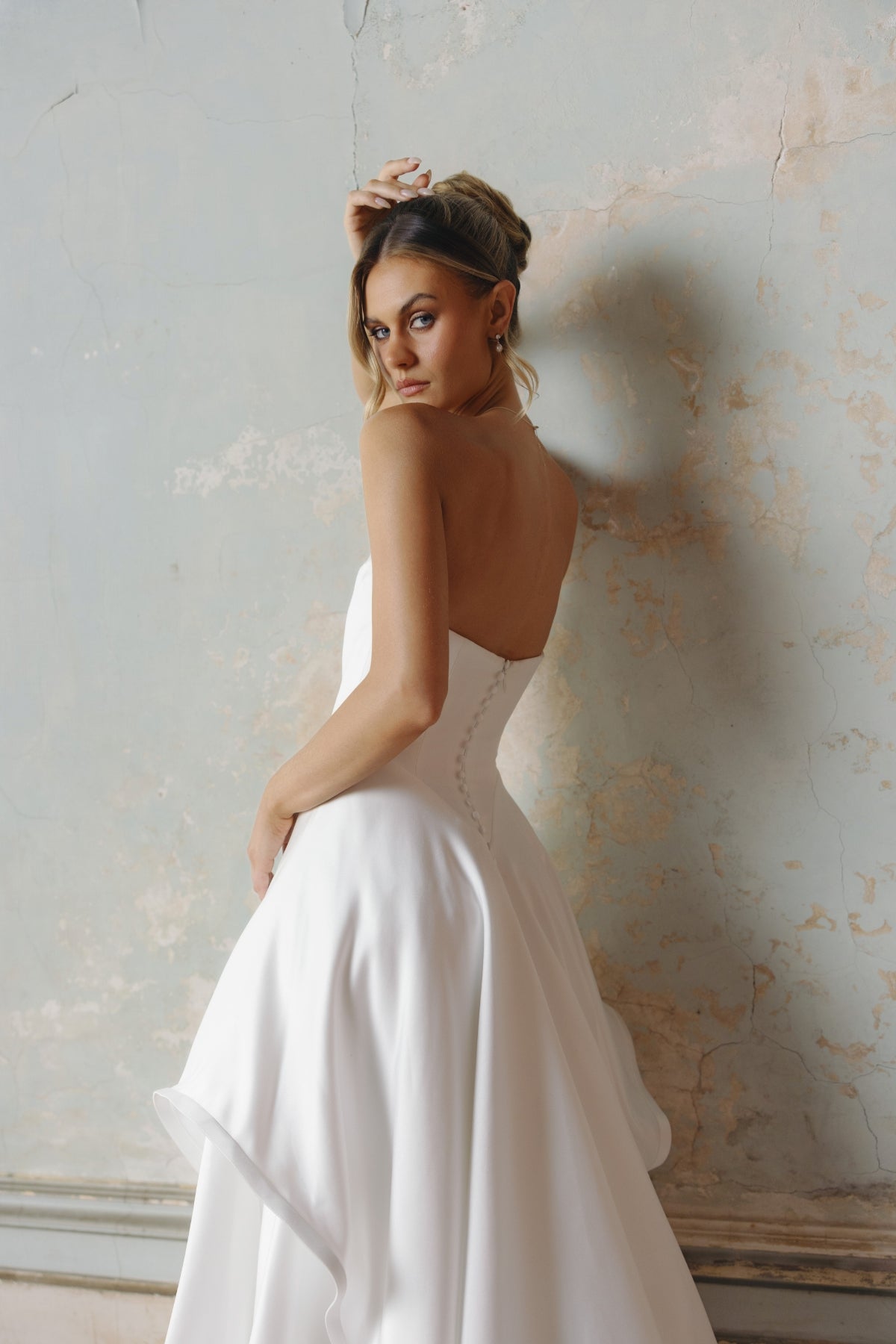 Strapless A-line satin wedding gown featuring cut drapes on the skirt 