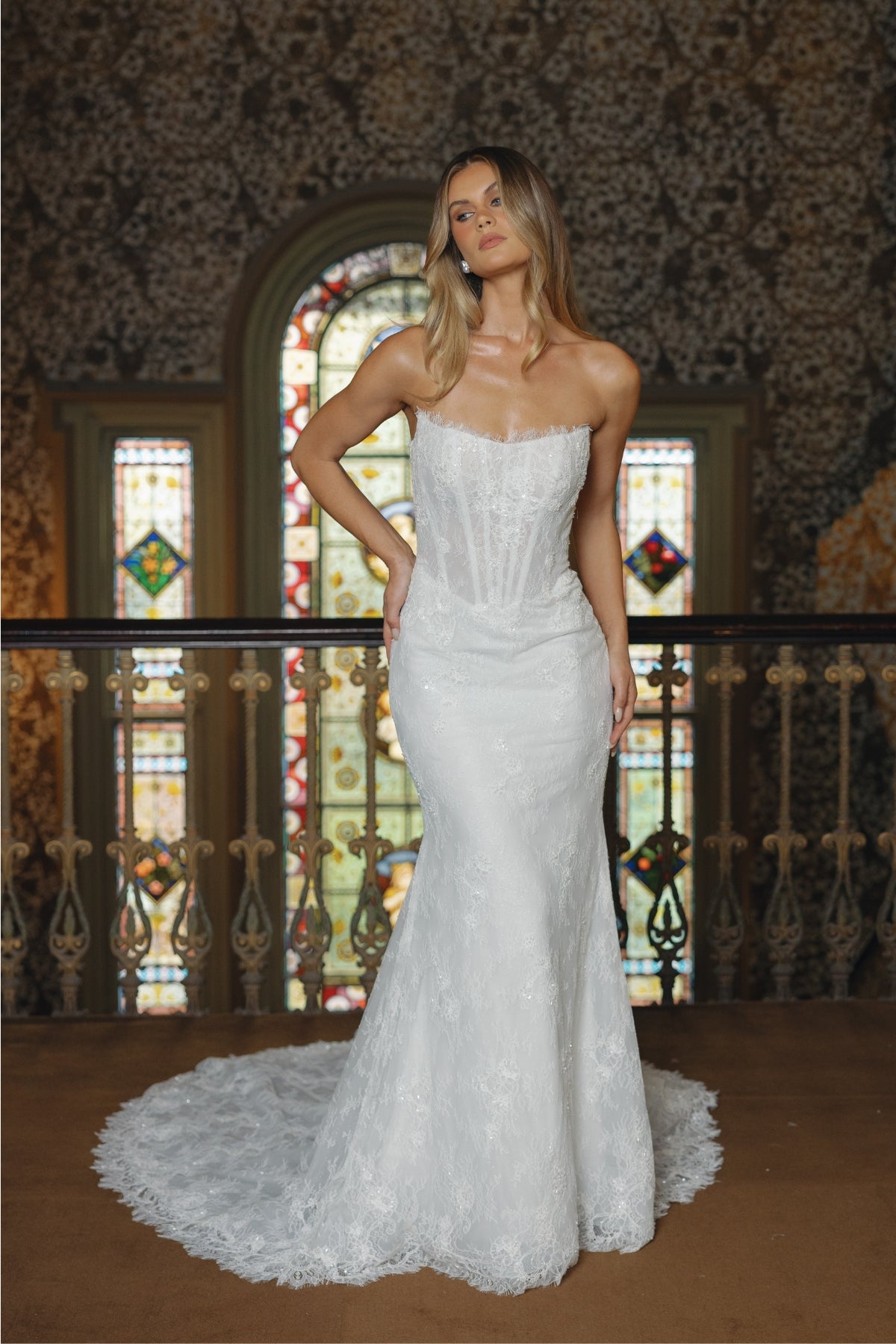 Fitted lace bridal gown featuring a cateye neckline, scalloped lace train. 