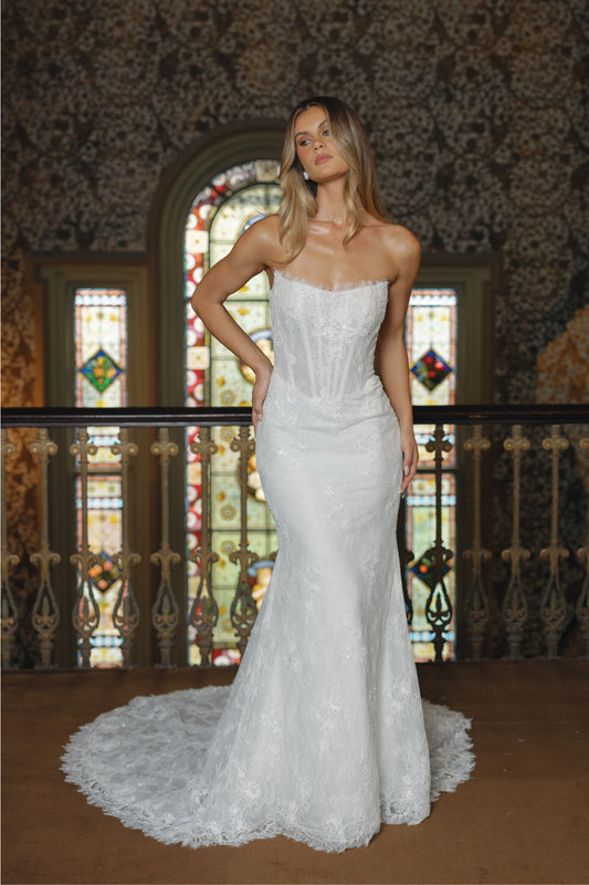 Fitted lace bridal gown featuring a cateye neckline, scalloped lace train. 