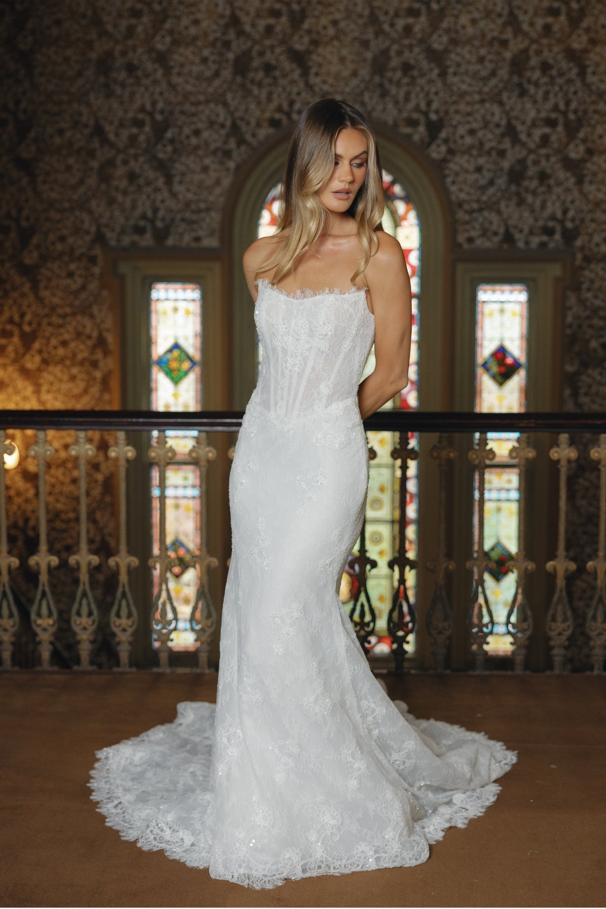 Fitted lace bridal gown featuring a cateye neckline, scalloped lace train. 