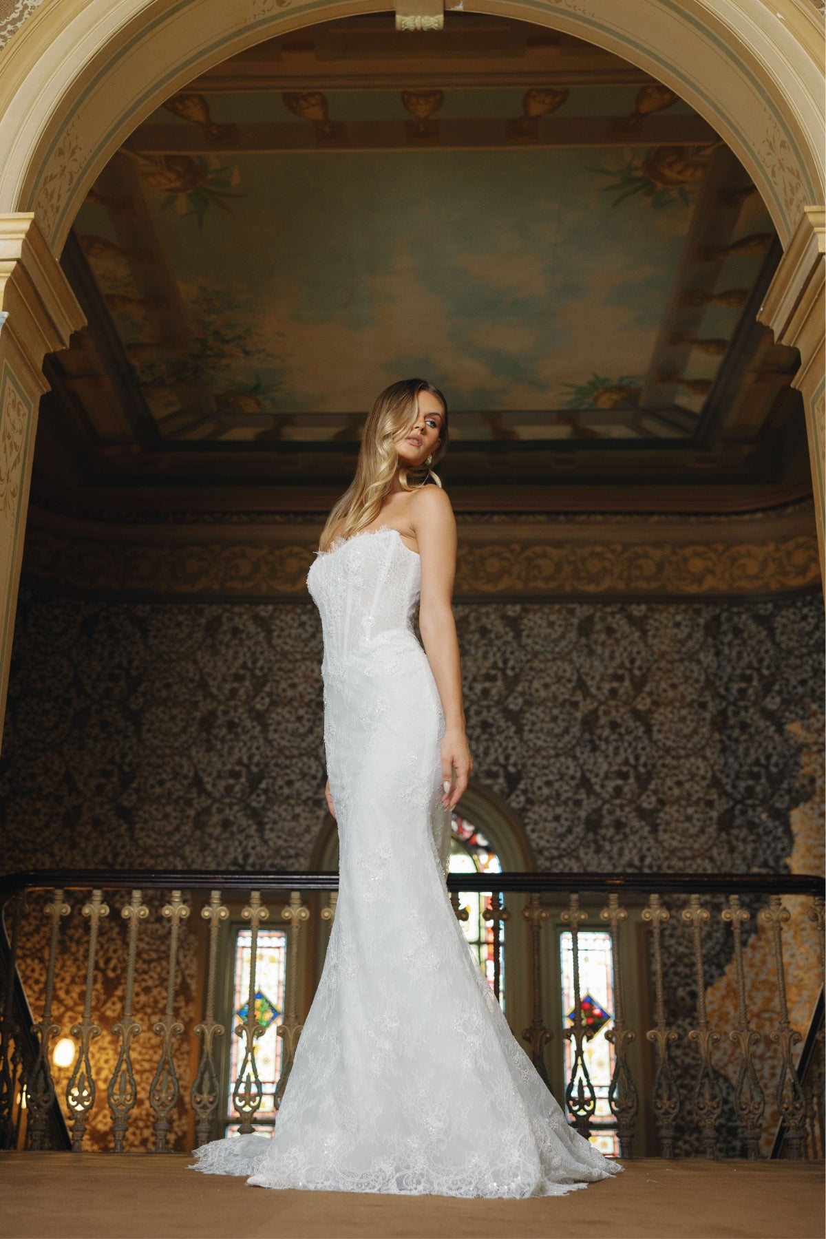 Fitted lace bridal gown featuring a cateye neckline, scalloped lace train. 