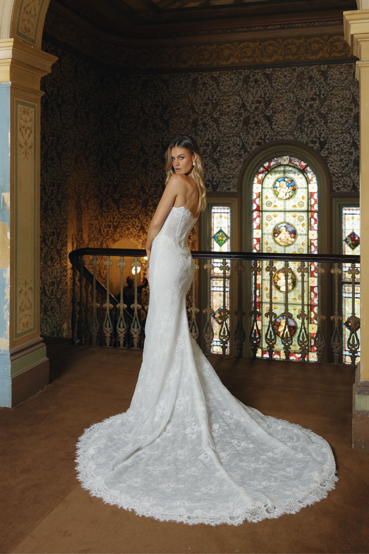 Fitted lace bridal gown featuring a cateye neckline, scalloped lace train. 