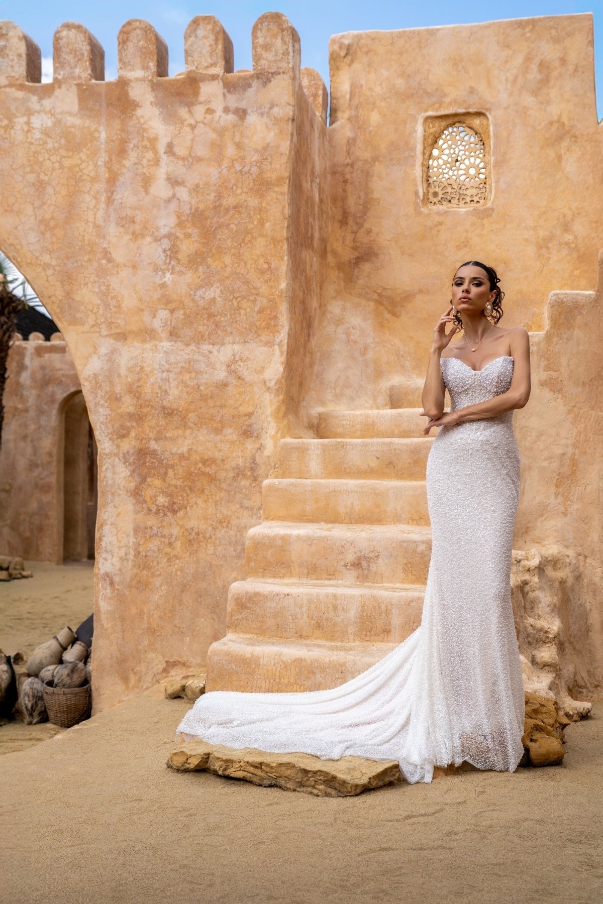 fitted wedding gown with beaded lace, covered in pearls, featuring cat-eye neckline and basque waist. 