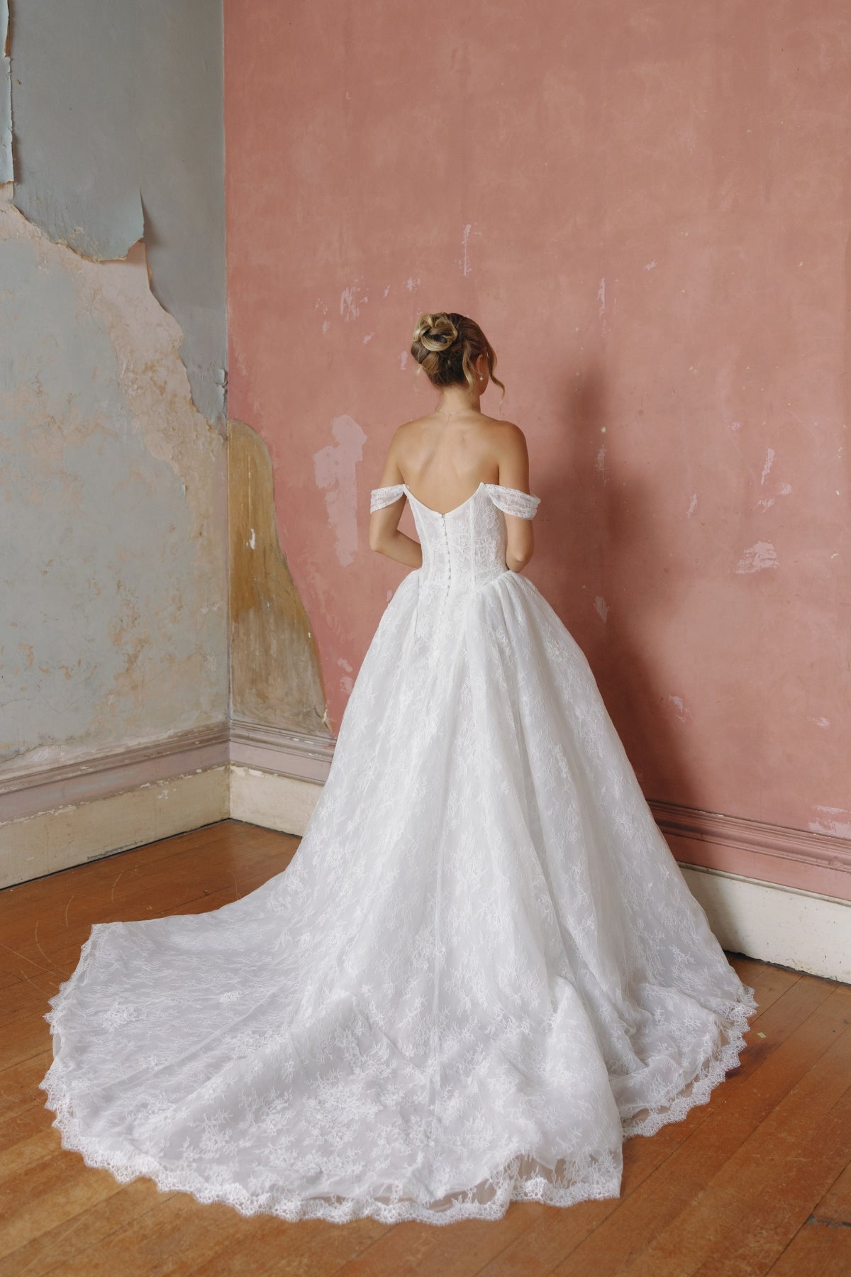 off the shoulder A-line wedding gown in lace, steep basque waist and ruched bust. 