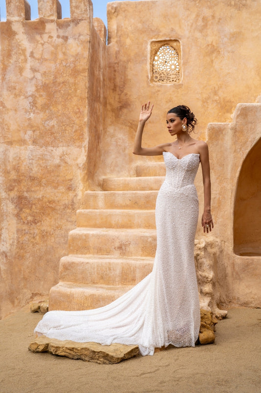 fitted wedding gown with beaded lace, covered in pearls, featuring cat-eye neckline and basque waist. 