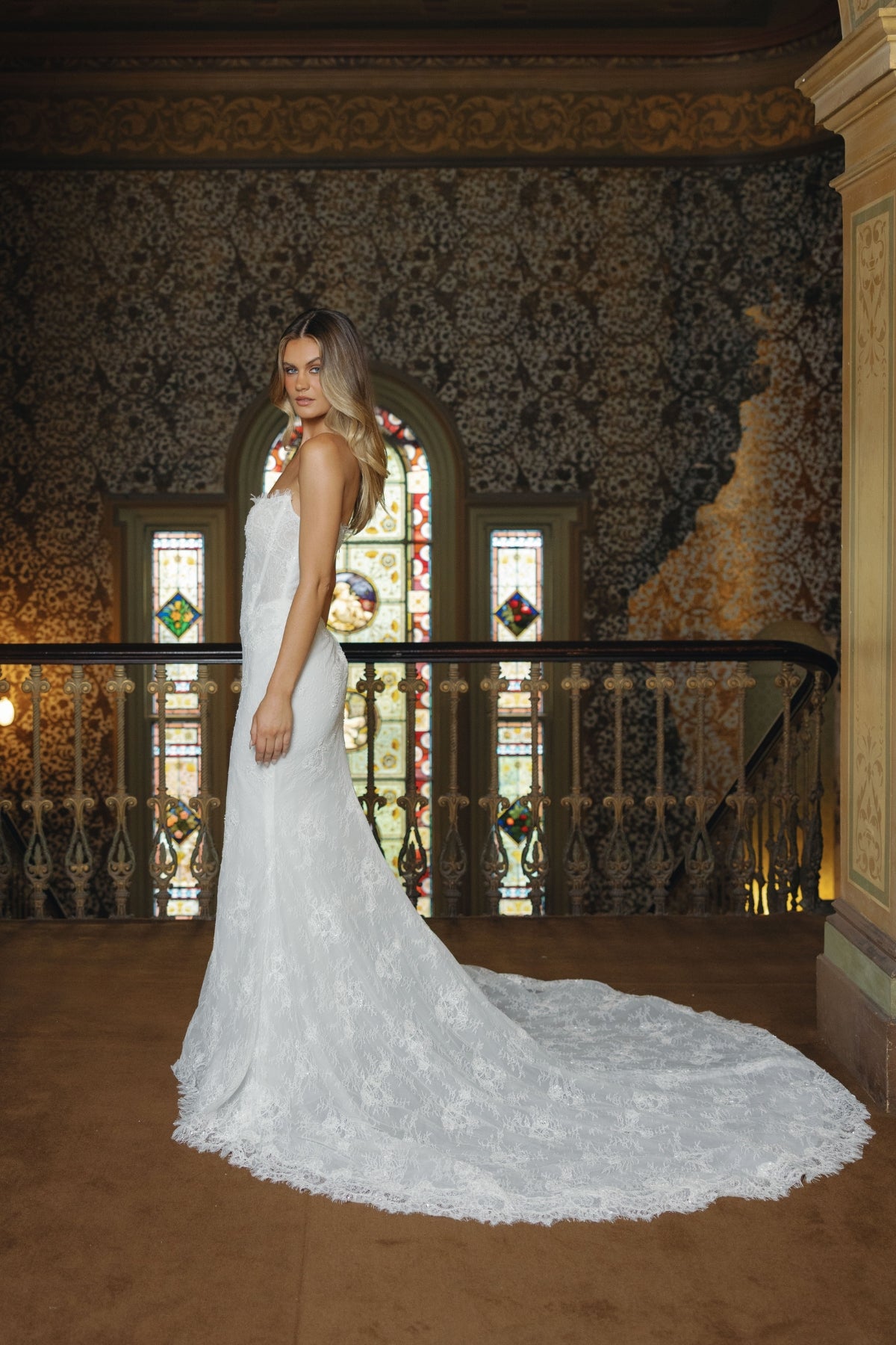 Fitted lace bridal gown featuring a cateye neckline, scalloped lace train. 