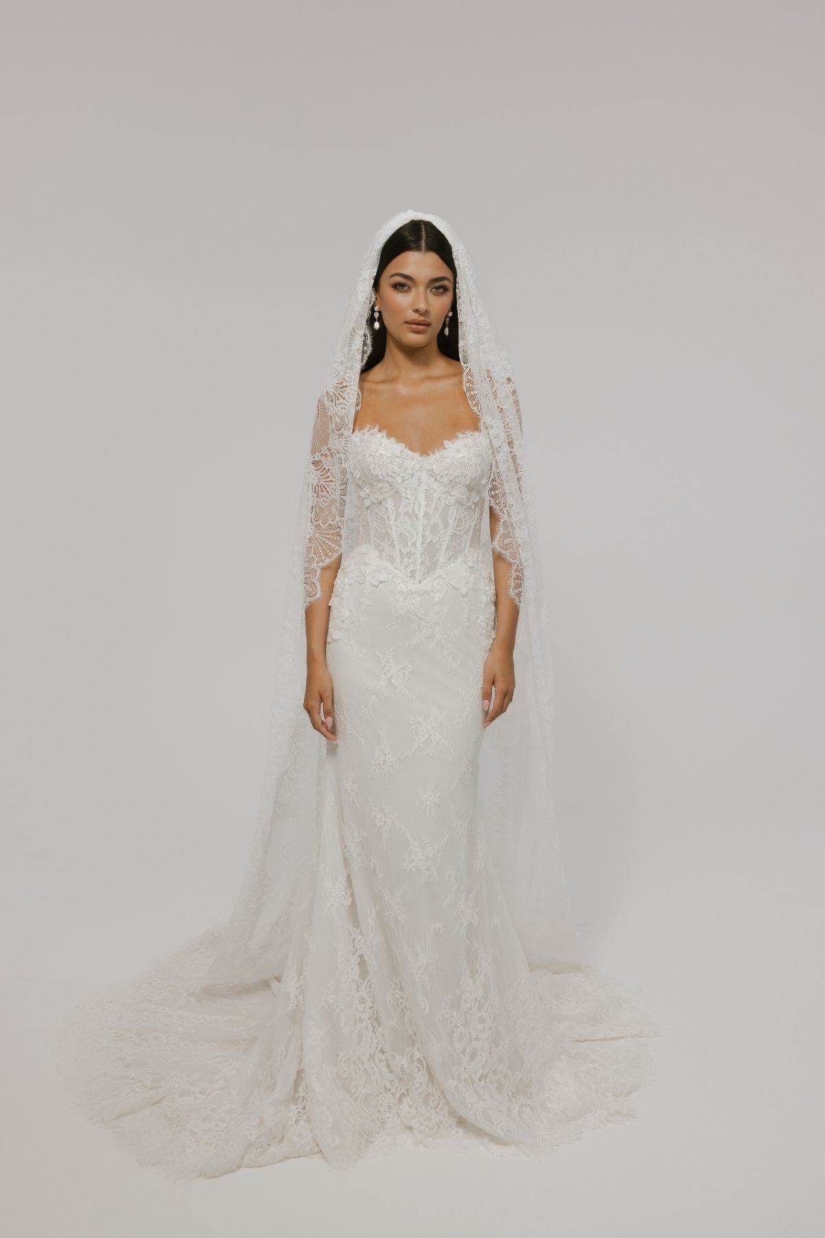 sweetheart neckline fitted wedding gown featuring basque waist and corset boning, with floral lace. 