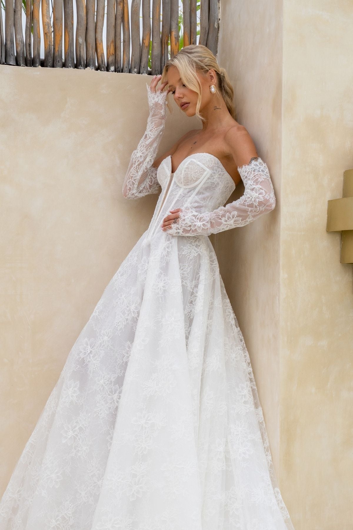 Lace A-line wedding gown with deep v plunge and sweetheart neckline, basque wasitline and fitted lace sleeves. 