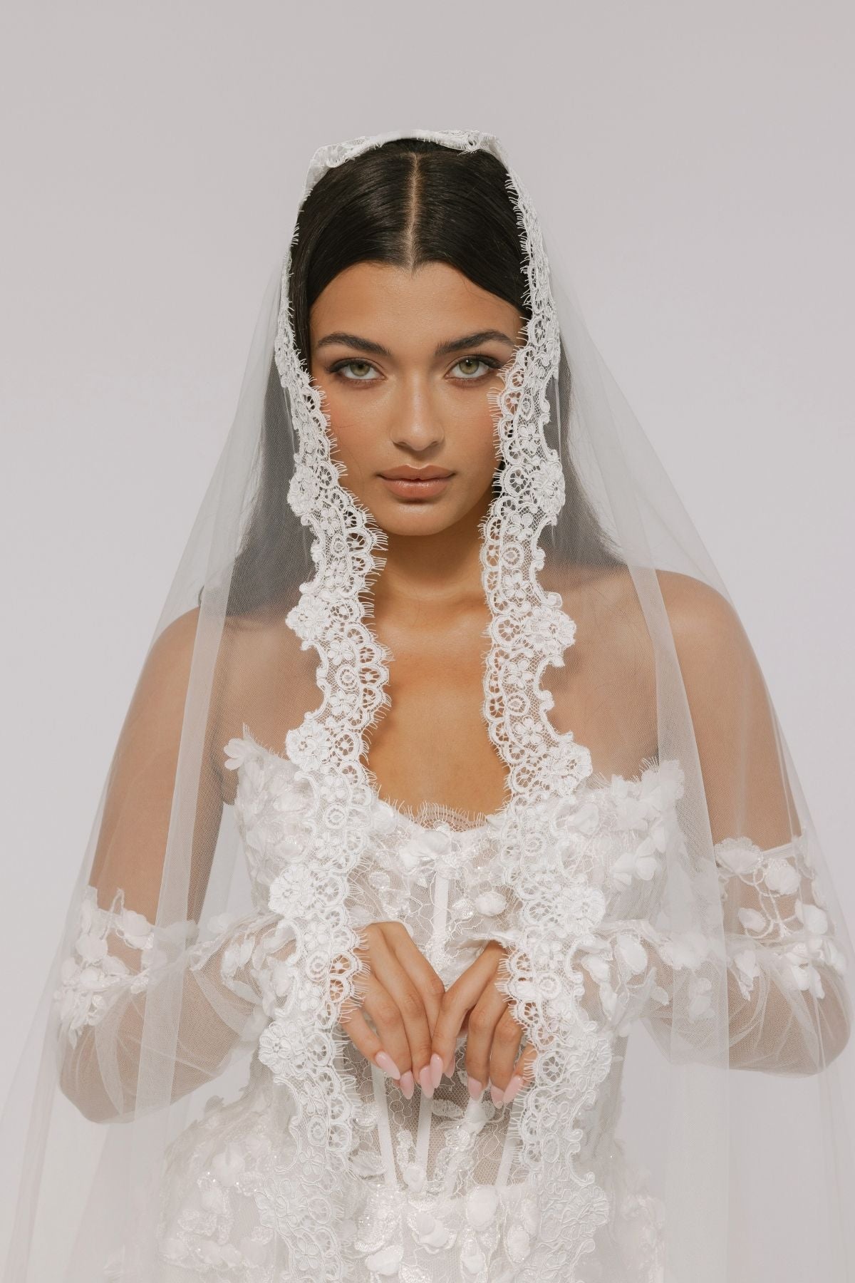 bride wears an elegant mantilla lace veil
