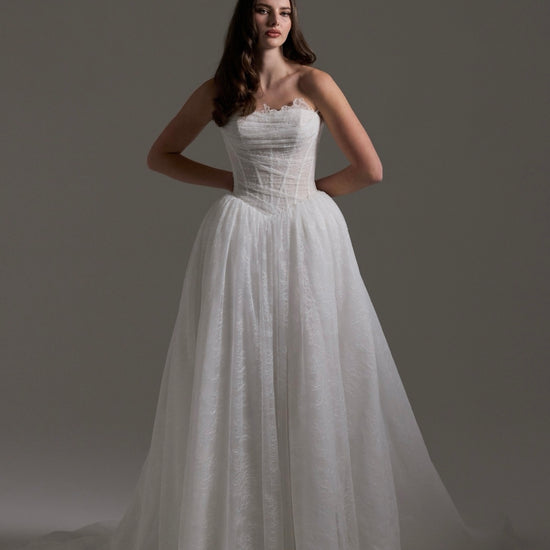 Lace wedding gown with A line skirt, featuring basque waist, strapless bodice and exposed corset boning 