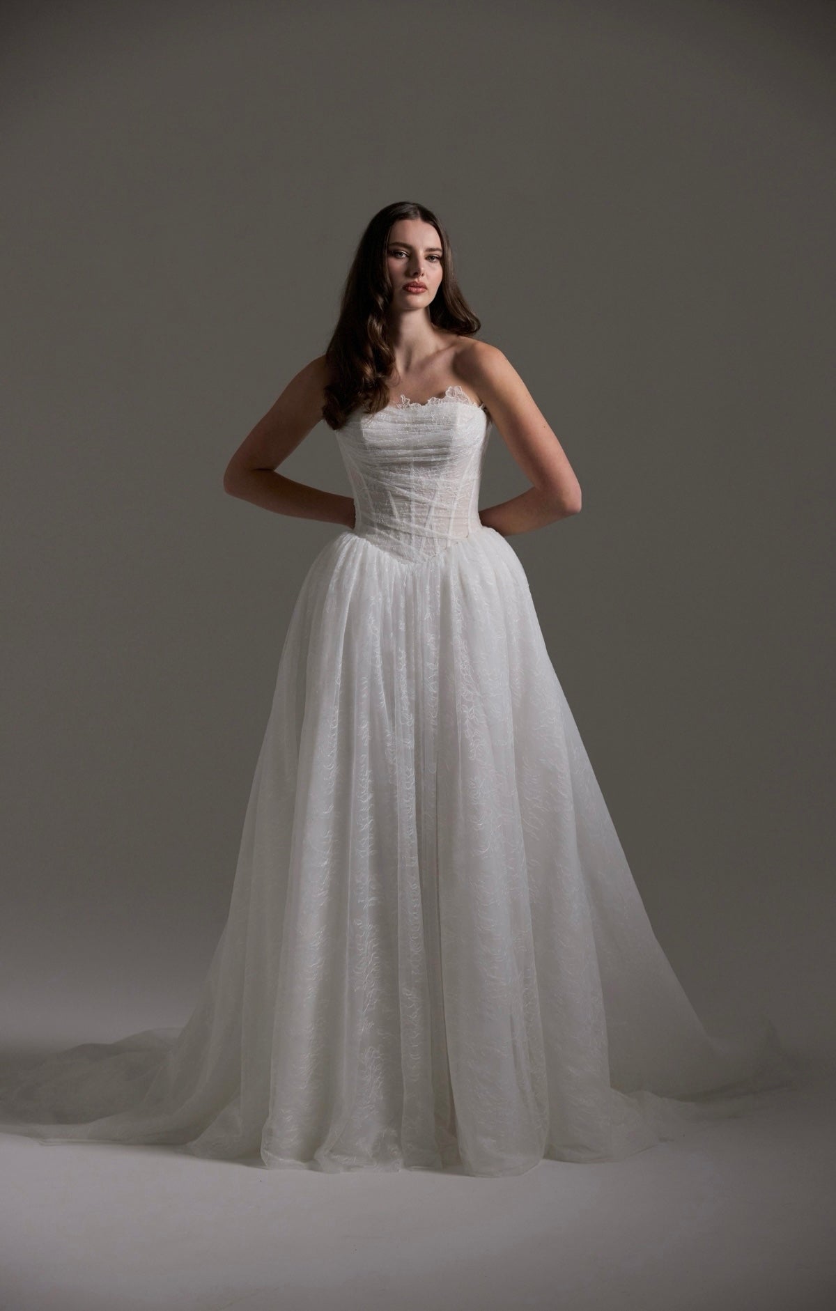 Lace wedding gown with A line skirt, featuring basque waist, strapless bodice and exposed corset boning 