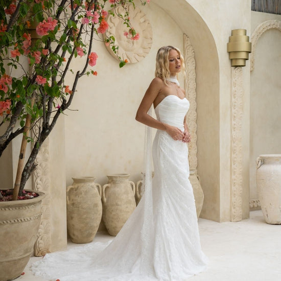 fitted lace wedding gown with sweetheart neckline, ruching across torso, paired with a lace scarf 