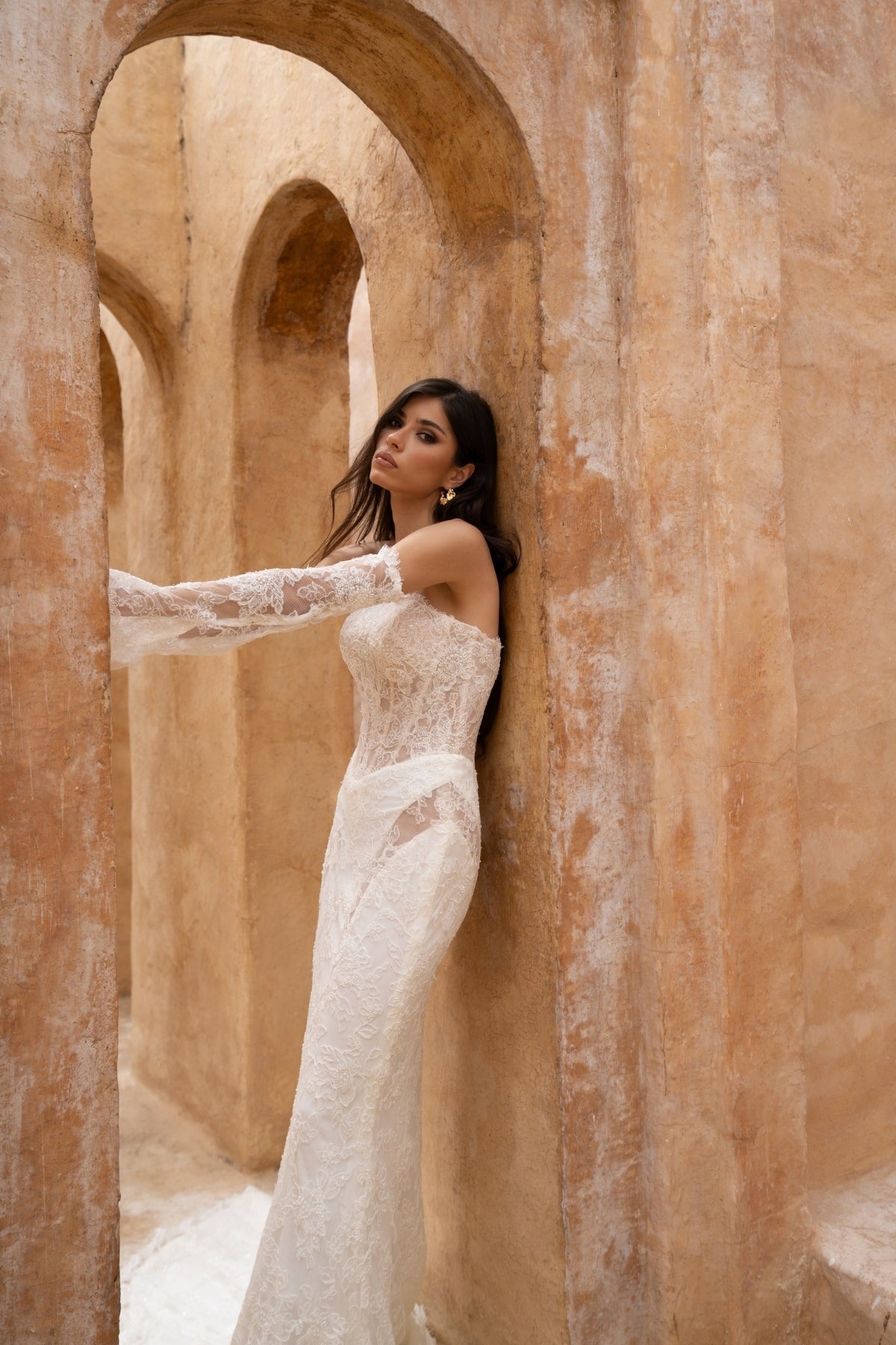 fitted lace wedding dress with basque waist, cat-eye neckline and side cut-outs. paired with fitted lace sleeves. 