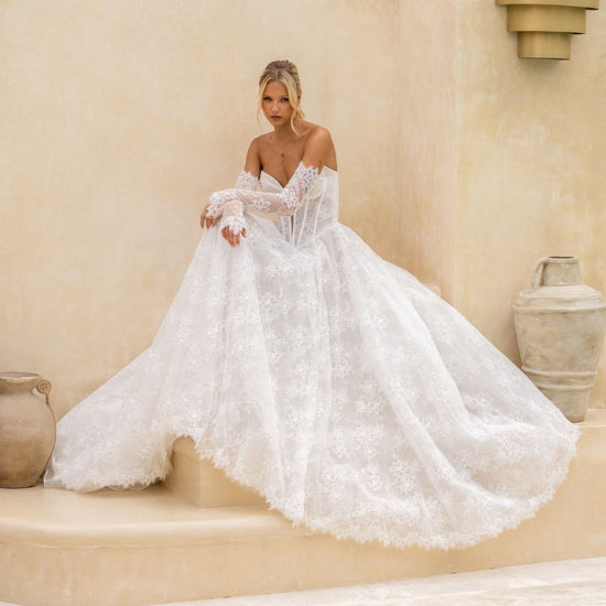 Lace A-line wedding gown with deep v plunge and sweetheart neckline, basque wasitline and fitted lace sleeves. 