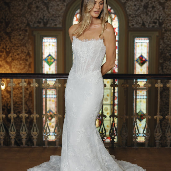 Fitted lace bridal gown featuring a cateye neckline, scalloped lace train. 