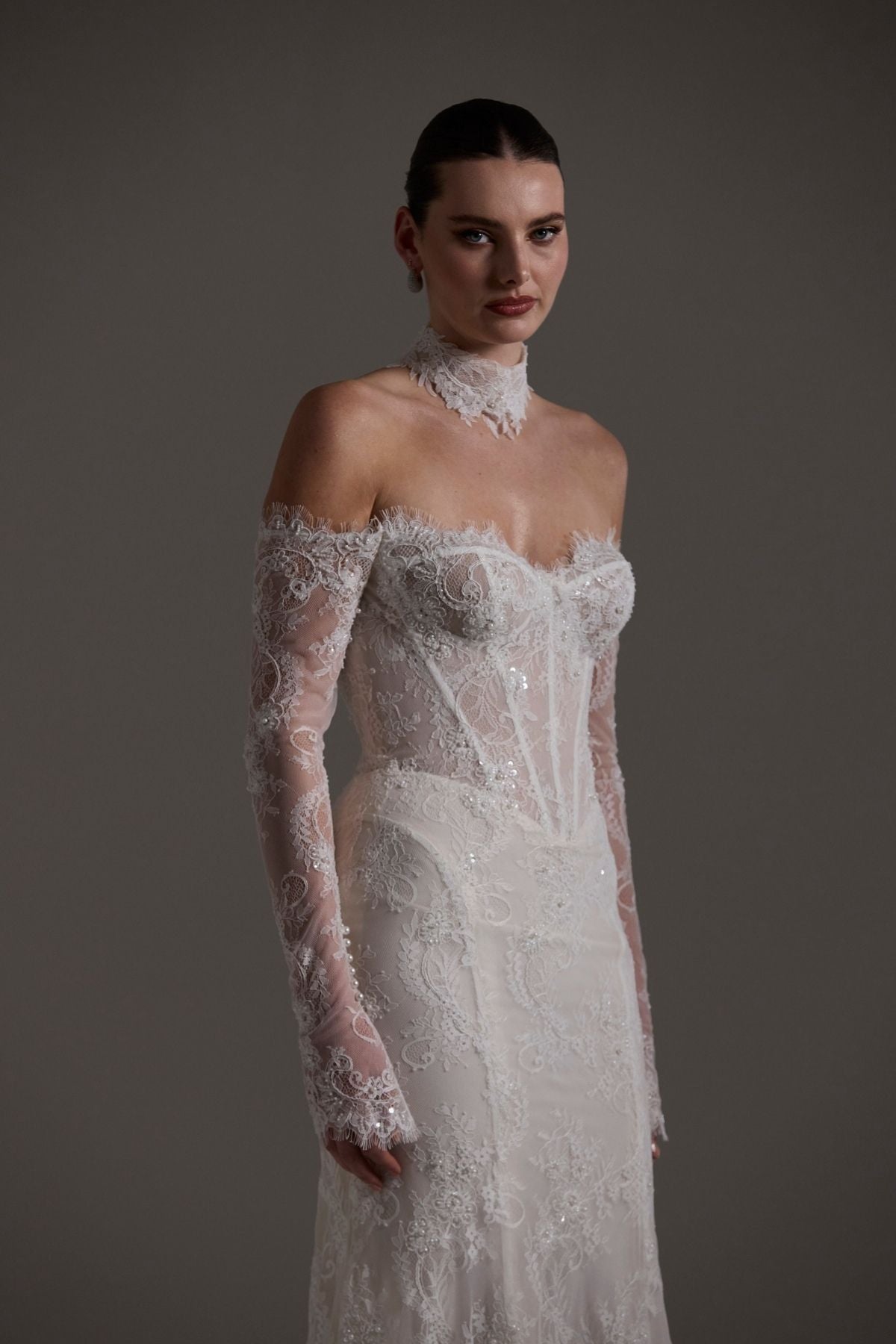 Fitted wedding gown featuring off-the-shoulder sleeves and neckline, vintage chantilly lace, basque waist, and lace choker. 